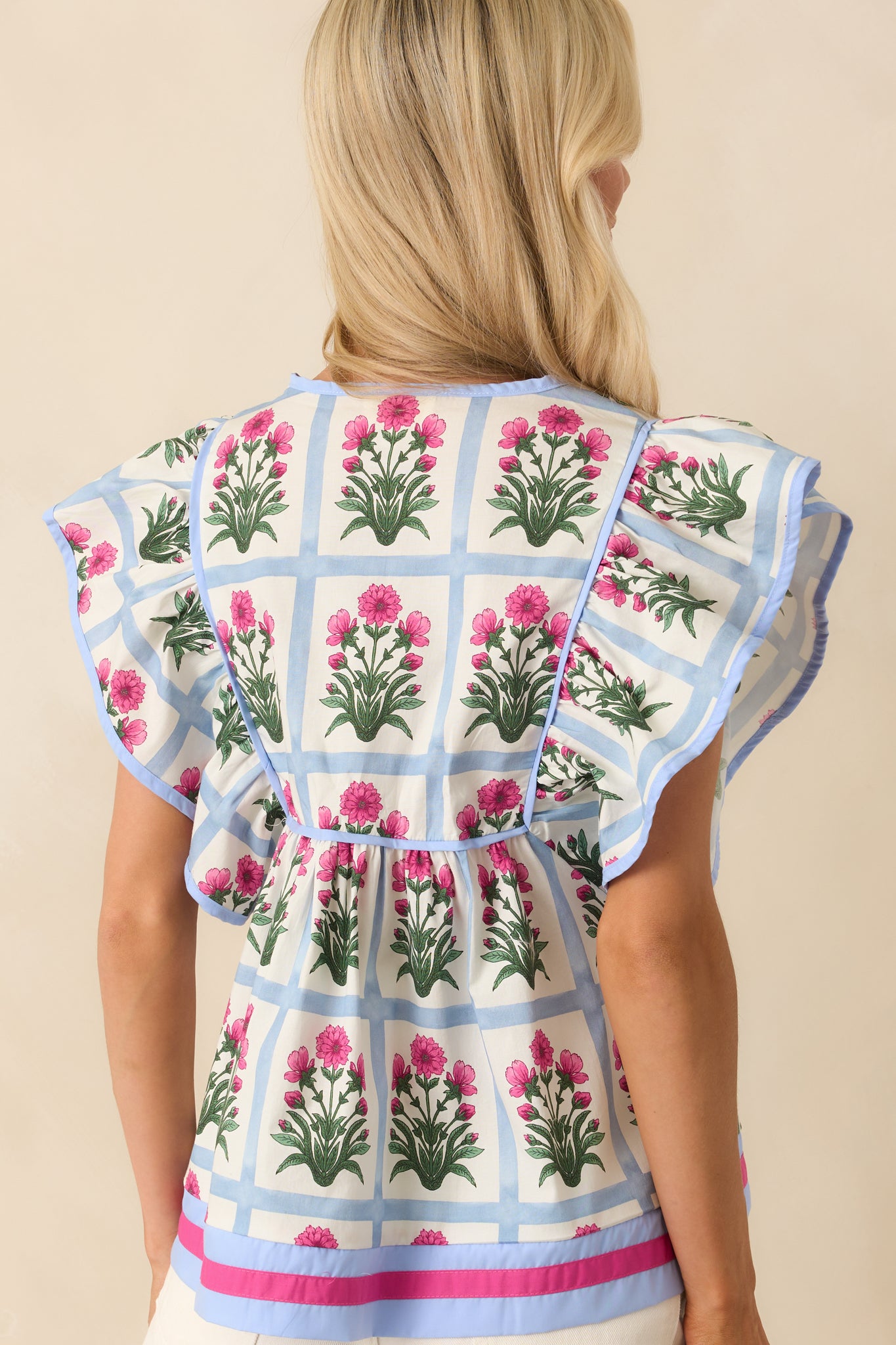A view from behind showing the full grid and floral print layout, flutter sleeves, and easy drape of the relaxed fit.