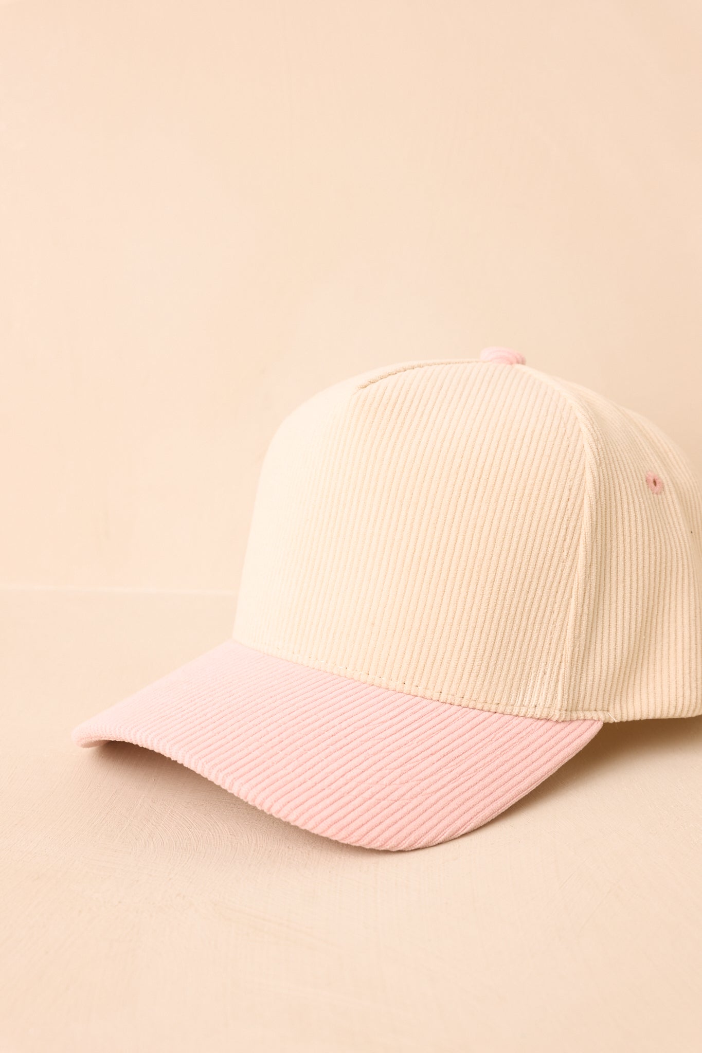 Beige and pink textured cap on a beige background.