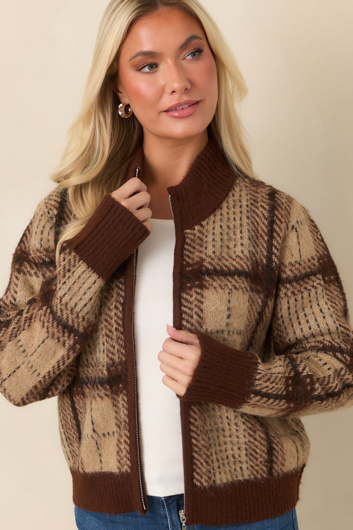 Beige and rich brown checked cardigan with a zip-front design and softly fuzzy knit texture.