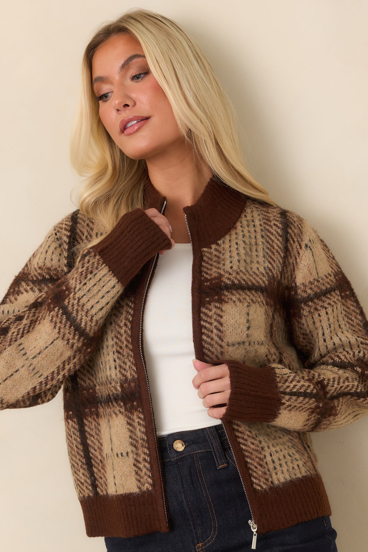 Beige and brown plaid cardigan featuring long sleeves finished with deep brown ribbed cuffs.