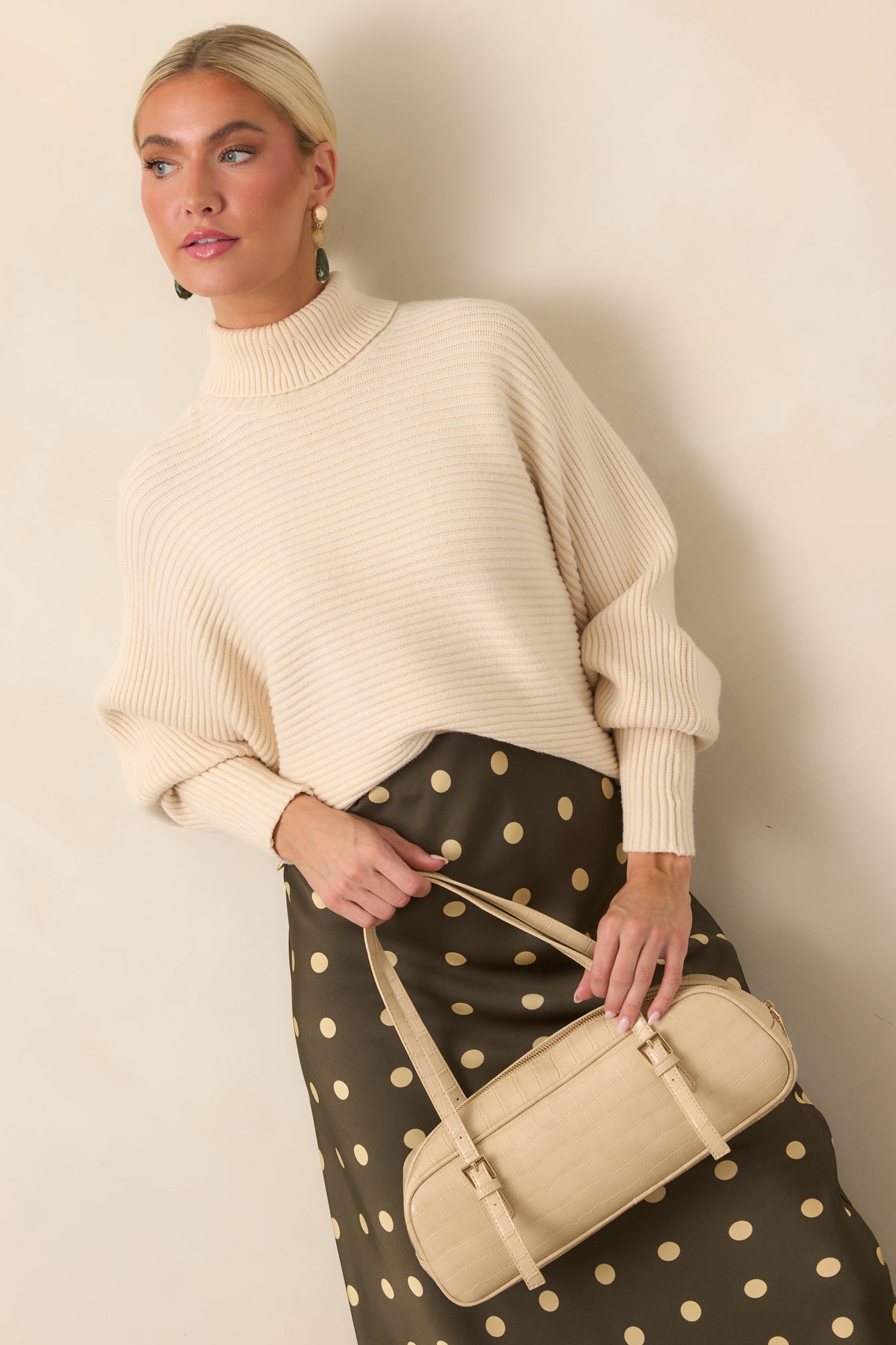 Button accents at the sleeve cuffs add a polished touch to the soft ribbed knit construction.