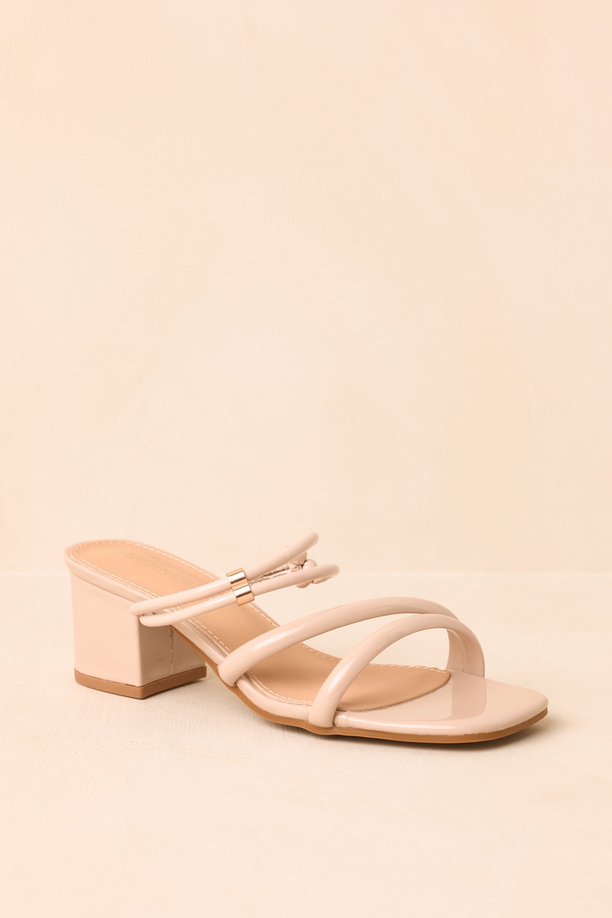Beige heels highlighting the covered block heel and clean slip-on silhouette.