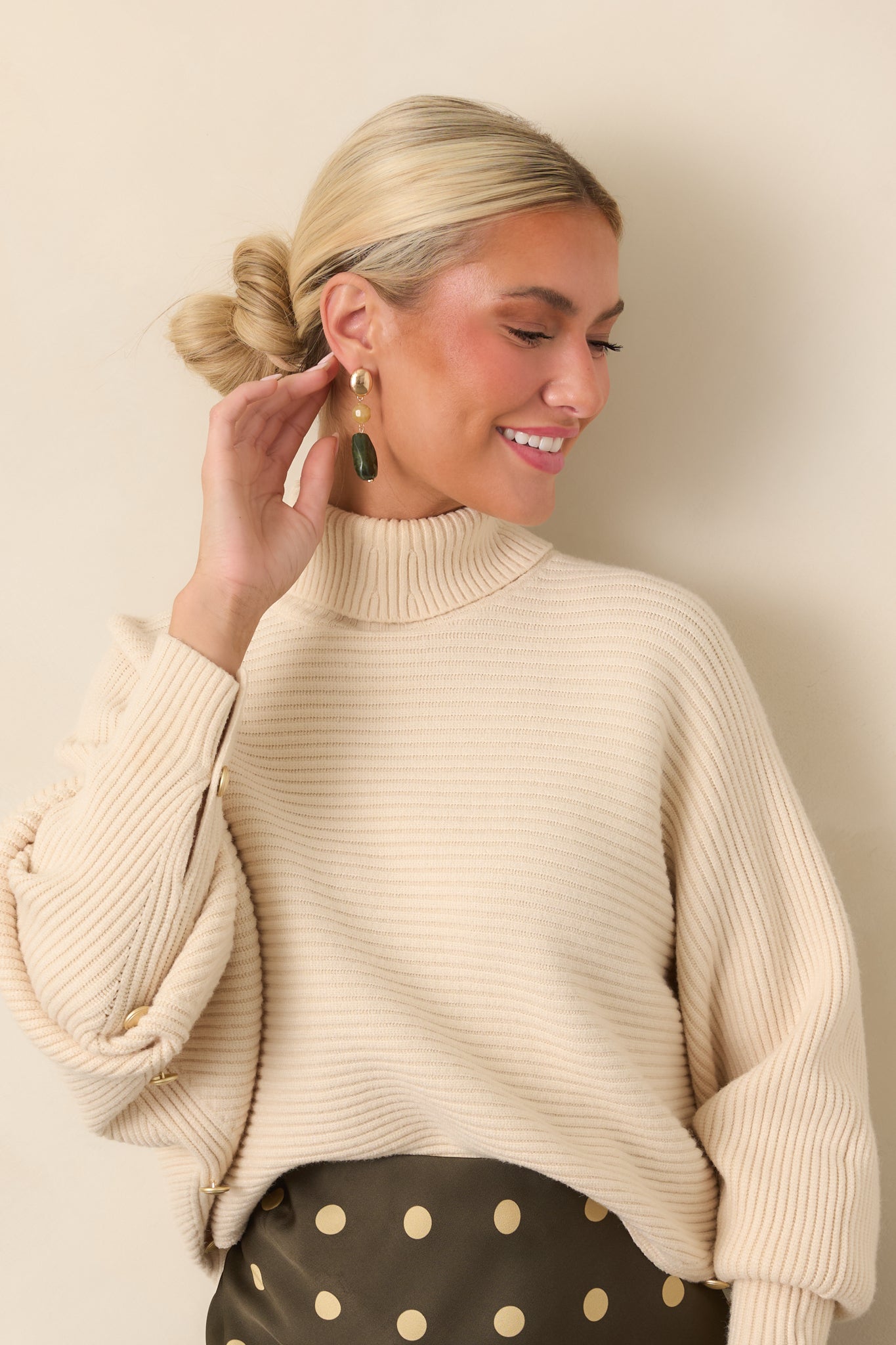 Draped batwing sleeves create a relaxed shape on this cozy beige rib knit pullover.