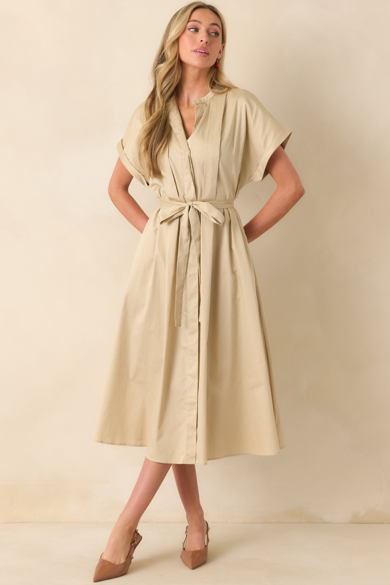 A beige dress with a functional button front, collared neckline, and a self-tie belt for a structured yet effortless look.
