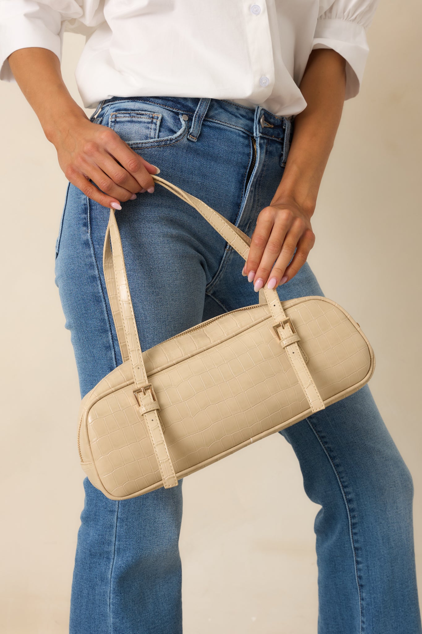 Beige faux crocodile leather handbag featuring structured top handles, a sleek silhouette, zipper closure, and polished texture.