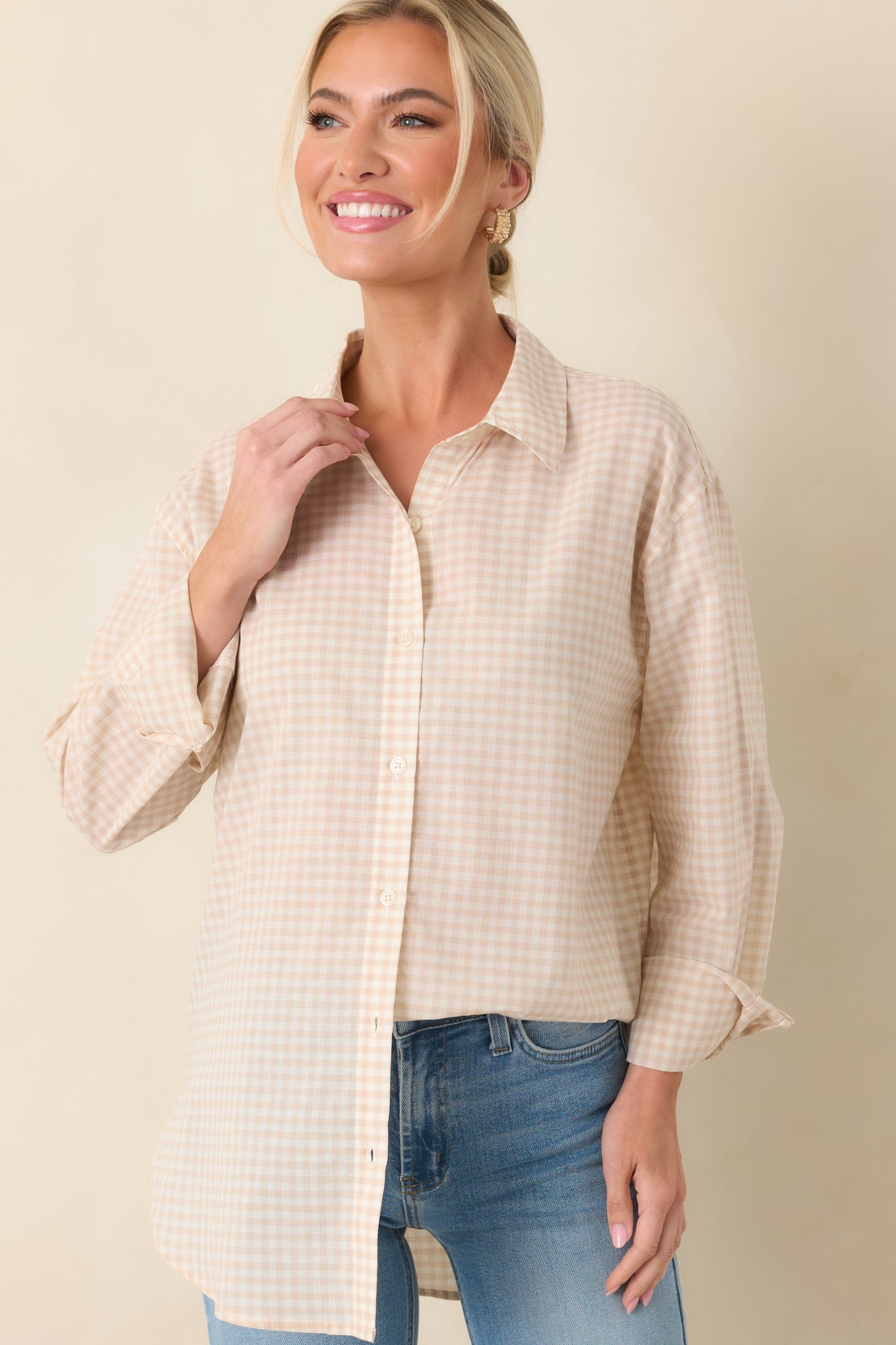 Front crop of beige gingham button-up highlighting the relaxed silhouette and rolled sleeves.