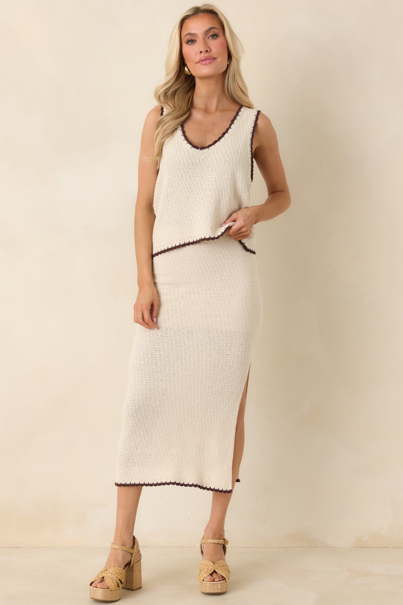 Relaxed-fit beige knit tank with V-neck front, contrasting stitched trim, and slightly shortened hemline.