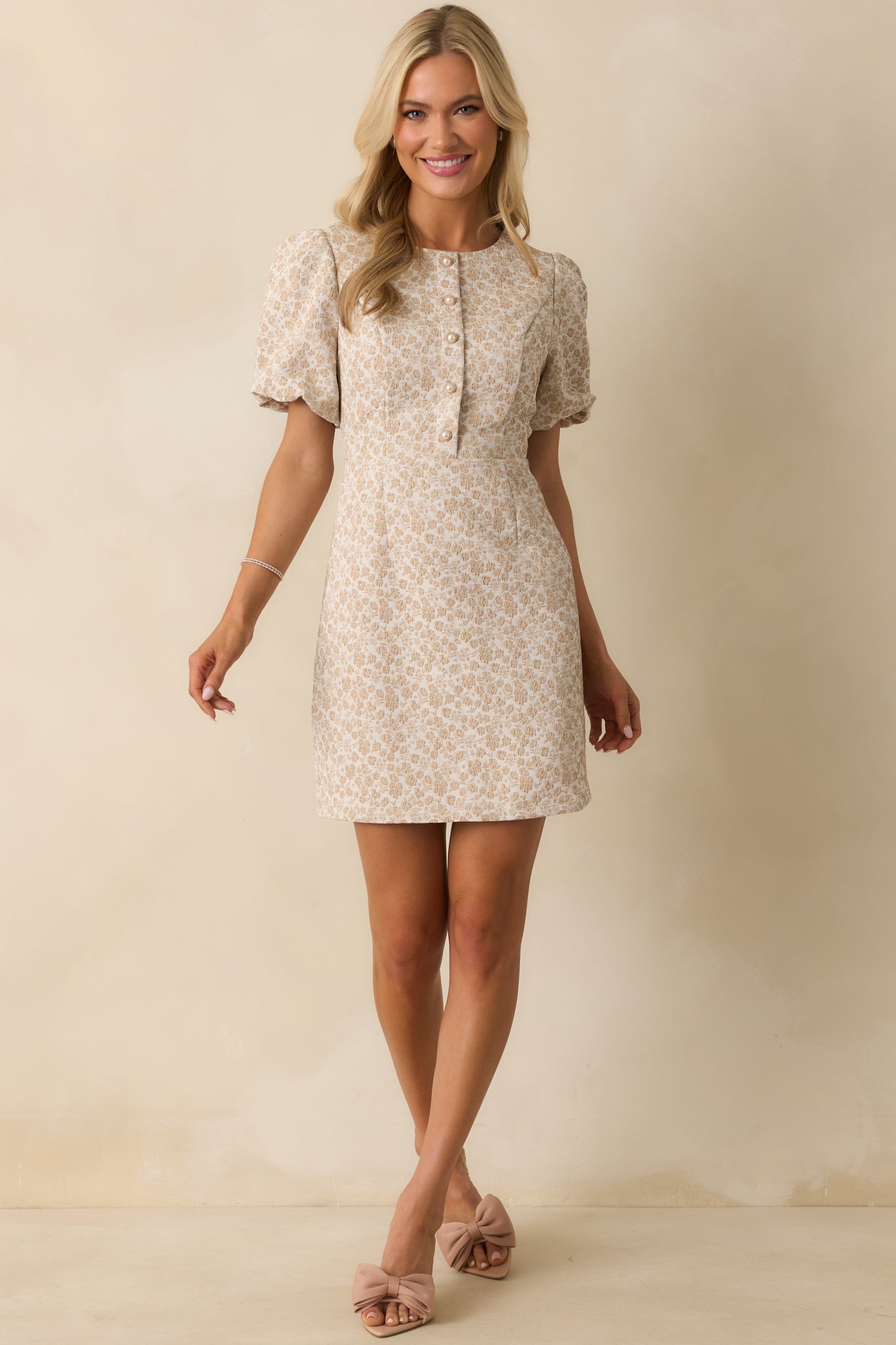 Structured beige mini dress highlighting short sleeves and fitted silhouette.