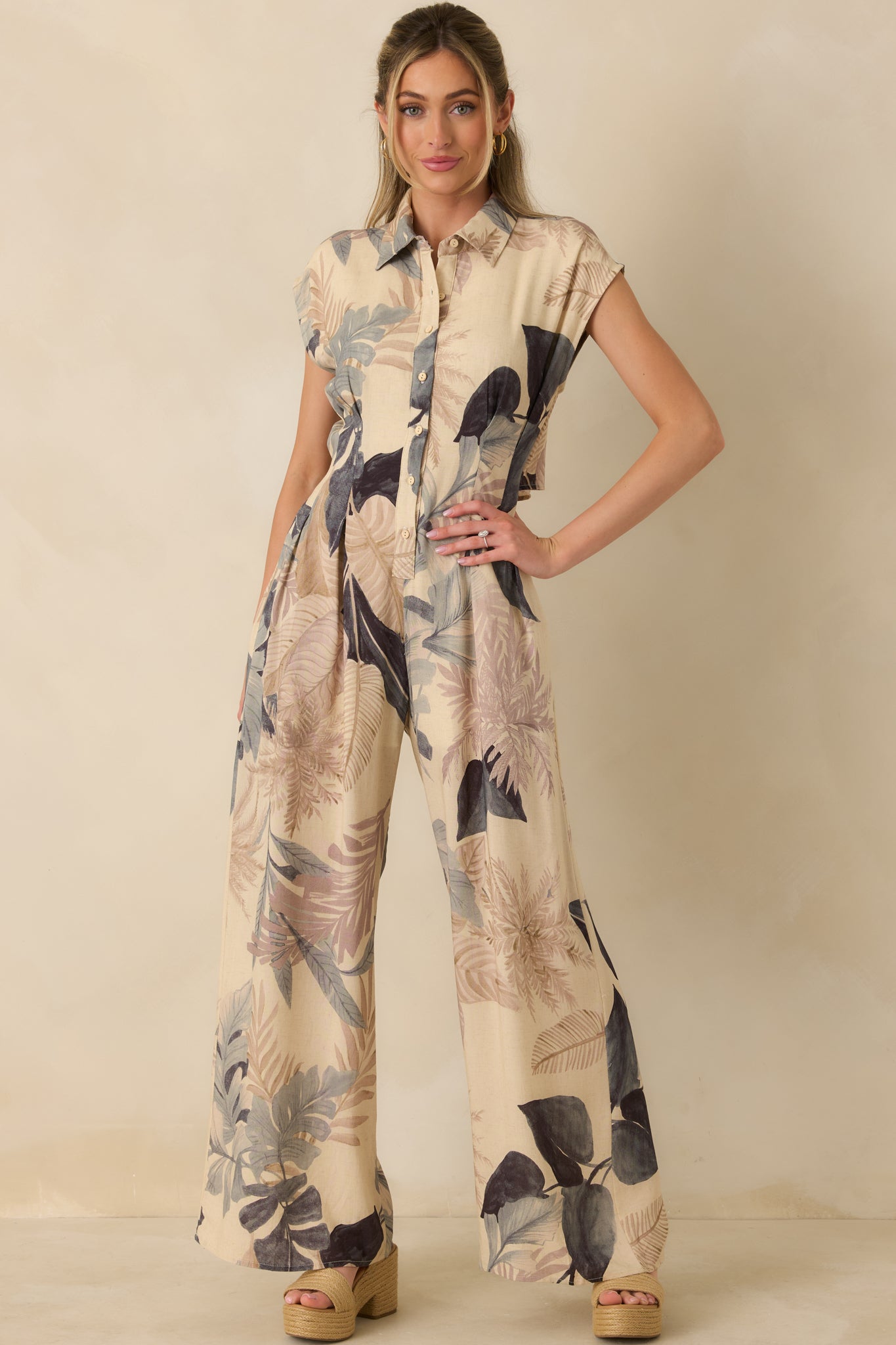 Beige multi-print jumpsuit showcasing relaxed wide-leg fit, cap sleeves, and breathable woven fabric.