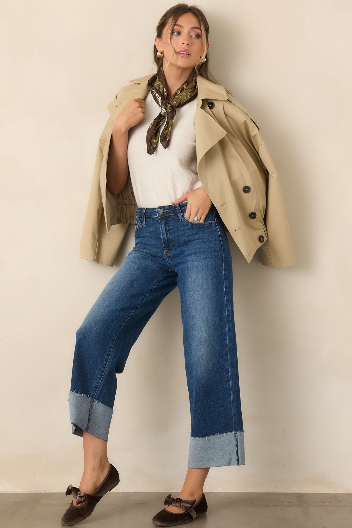 A structured notched collar complements the relaxed silhouette and cropped length of this beige trench jacket.