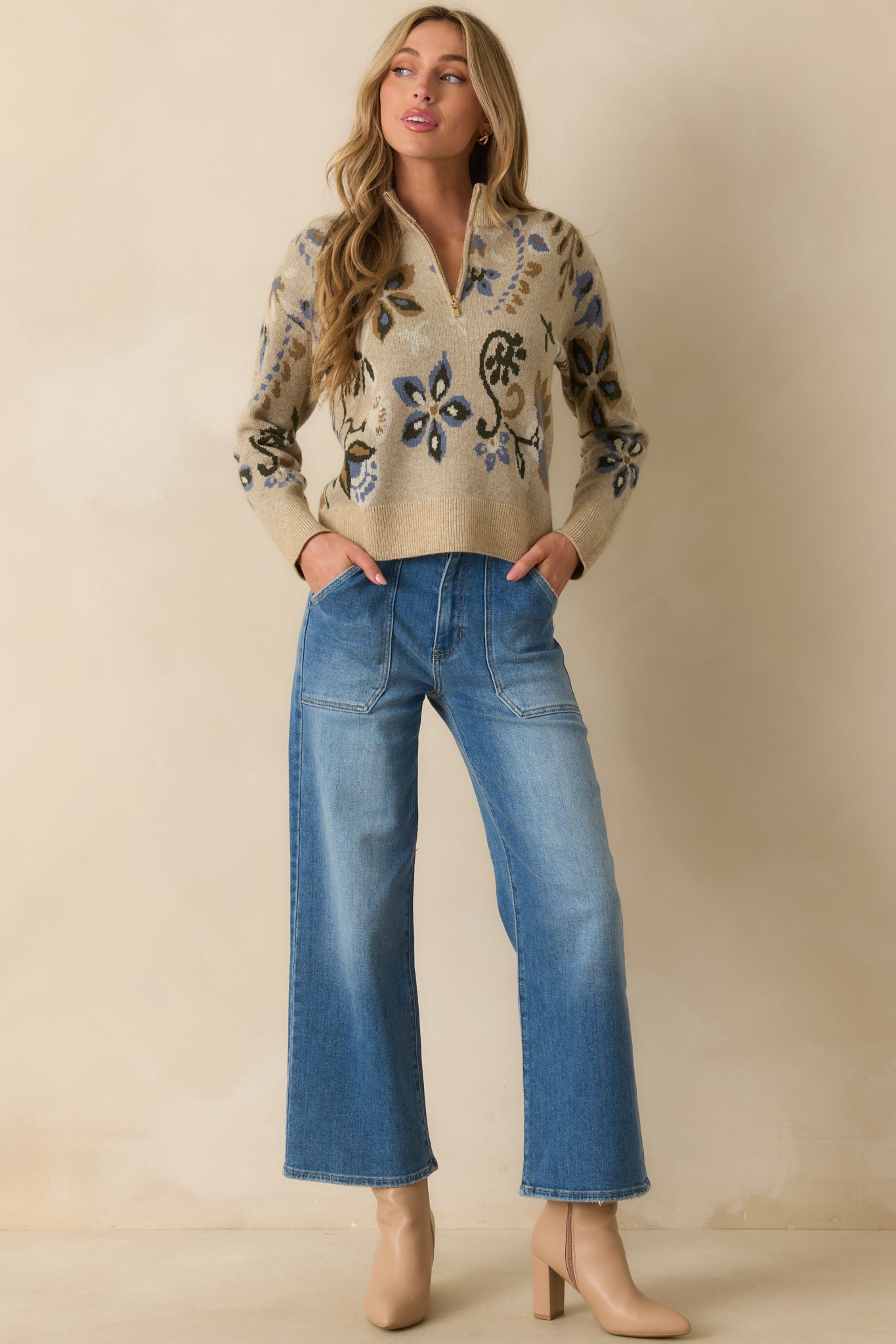 Relaxed fit beige knit sweater with long sleeves, ribbed hem, and an allover blue multicolor floral print.