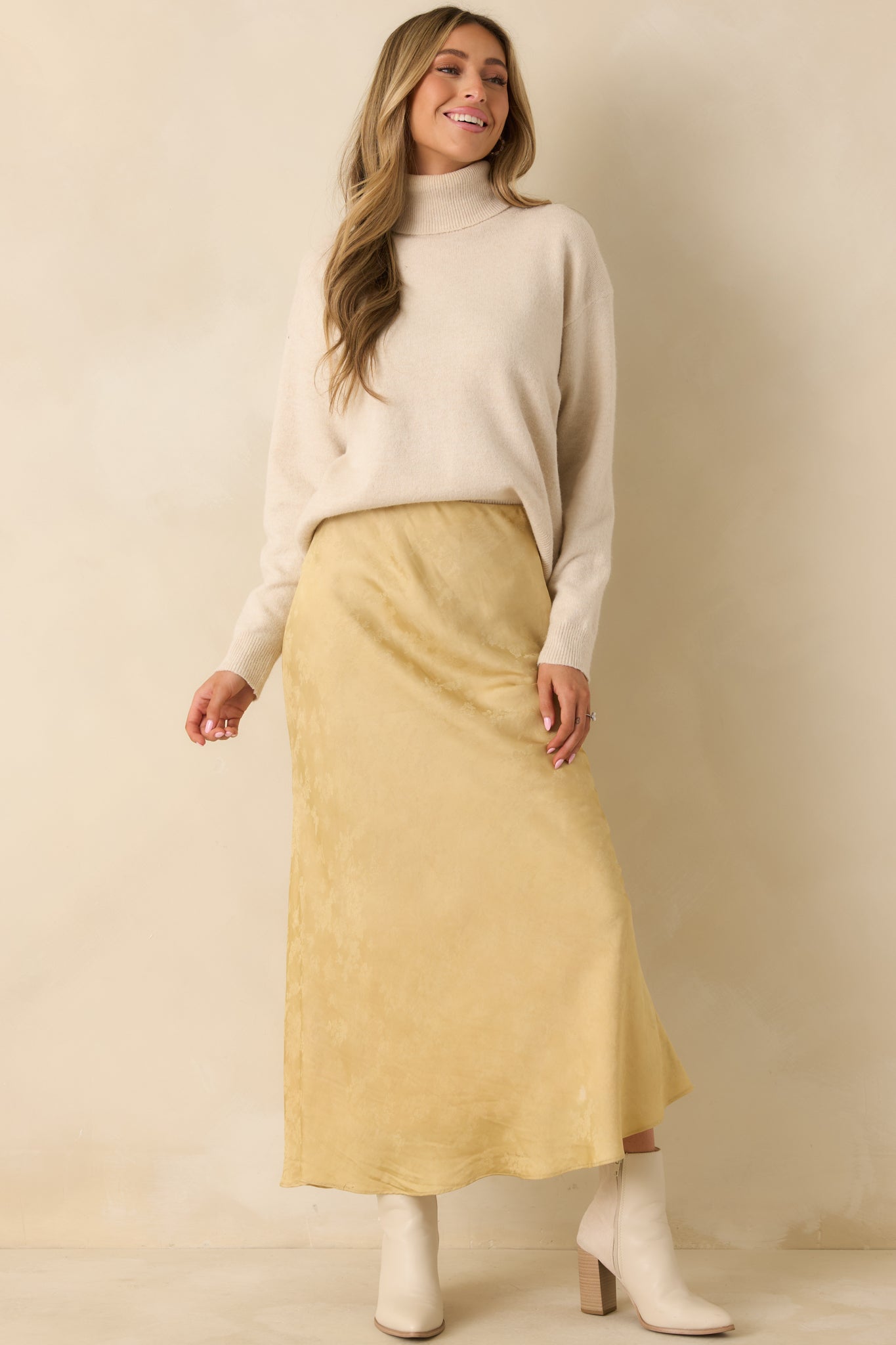 The relaxed fit of the beige sweater is paired with ribbed edges at the cuffs and hem.