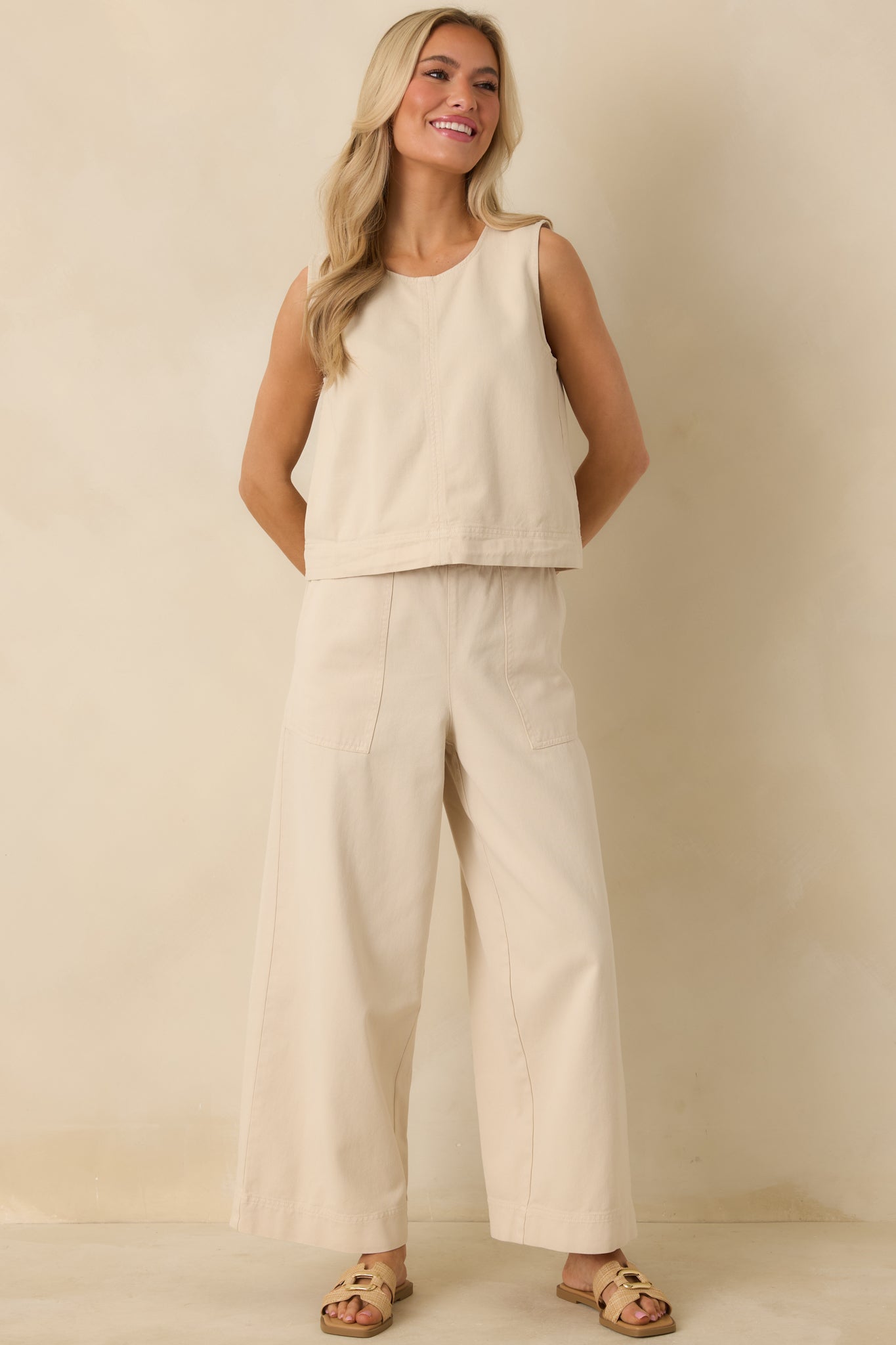 Beige wide-leg pants with a relaxed fit, elastic waistband, adjustable drawstring, and functional front patch pockets.