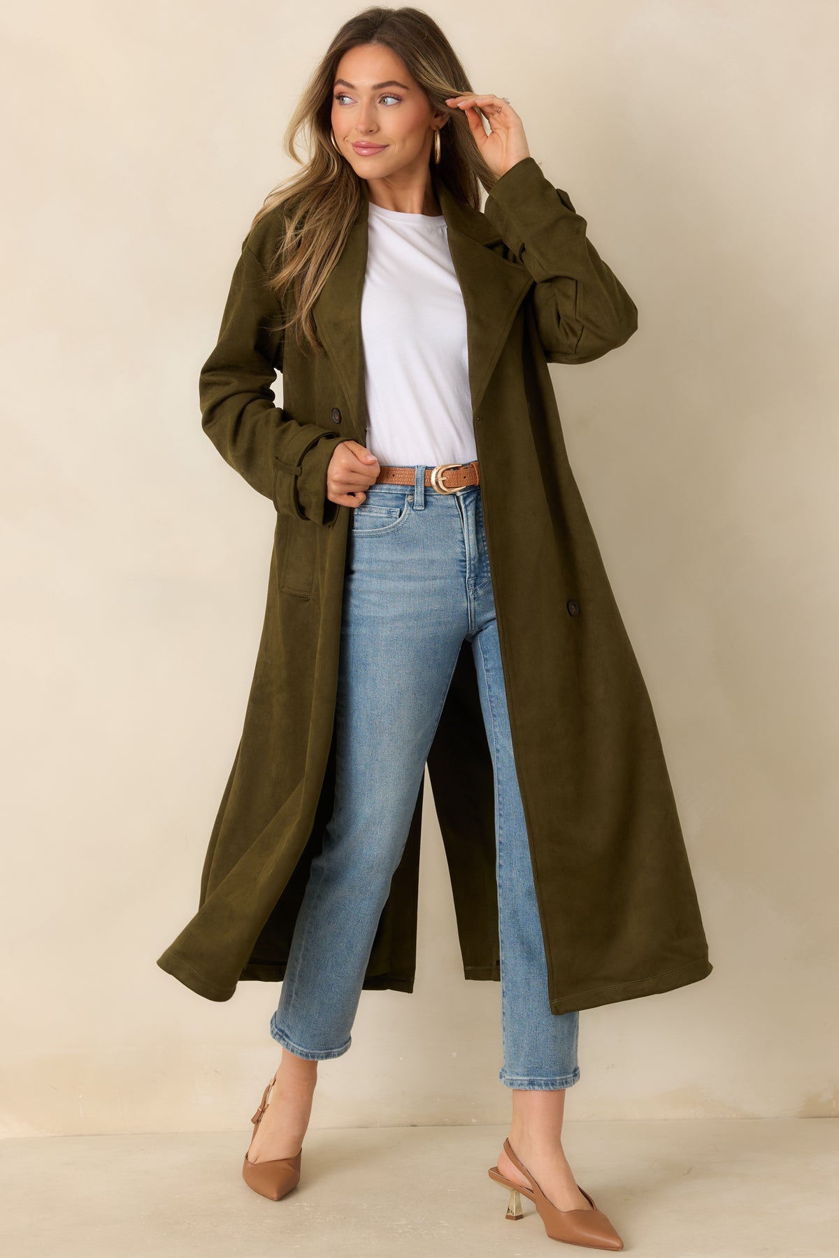 Belted coat featuring a double-breasted closure, buttoned cuff tabs, and a long silhouette.