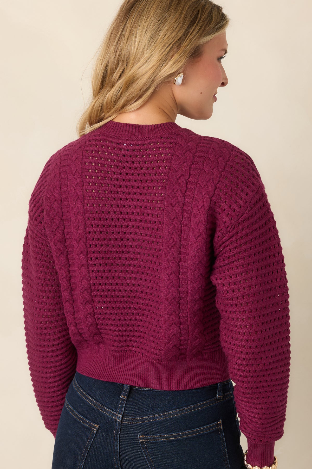Rear of the berry cropped sweater showcasing its open knit design and ribbed trim.