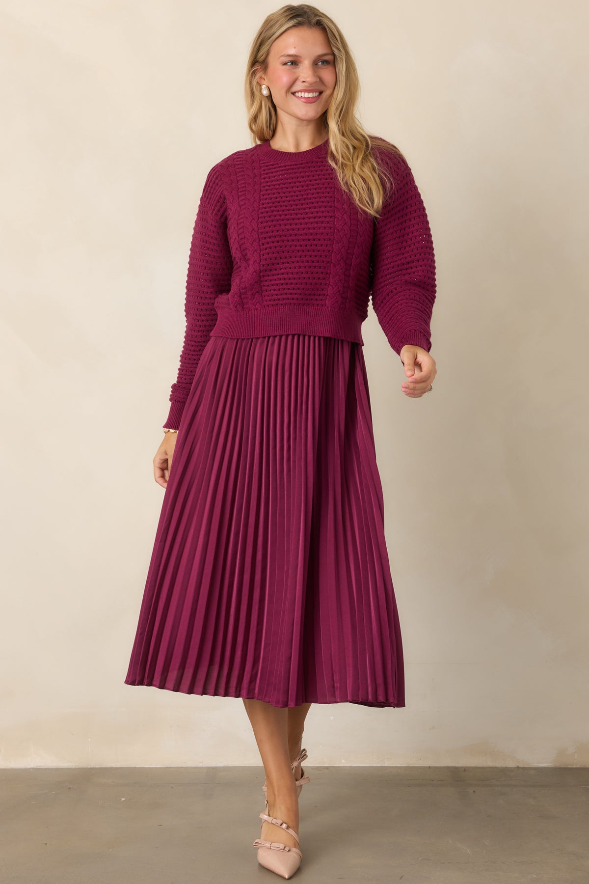 Berry knit and satin set showcasing the cropped sweater, V-neckline, and flowing pleated skirt.
