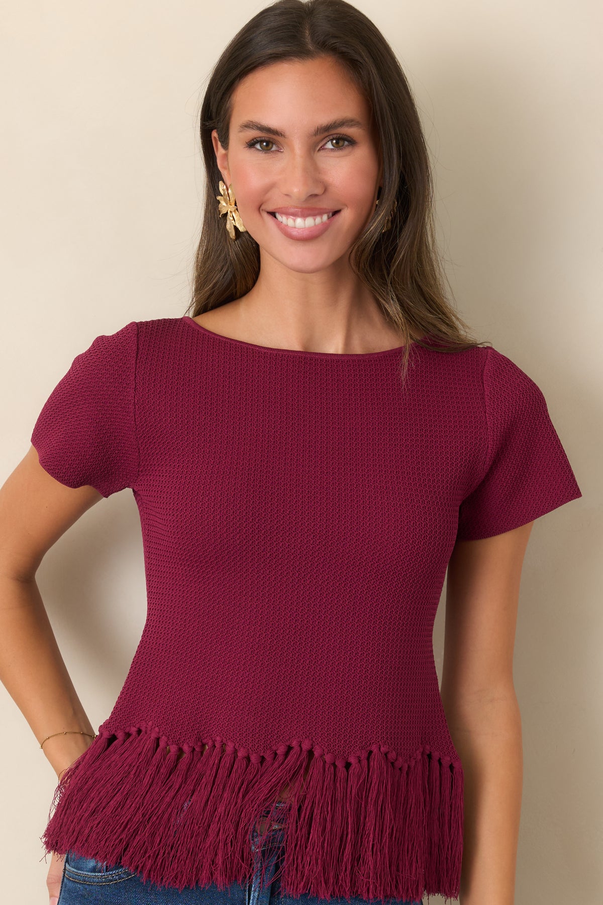 Berry short-sleeve top showcasing the textured knit and flowing fringe-trimmed hem.