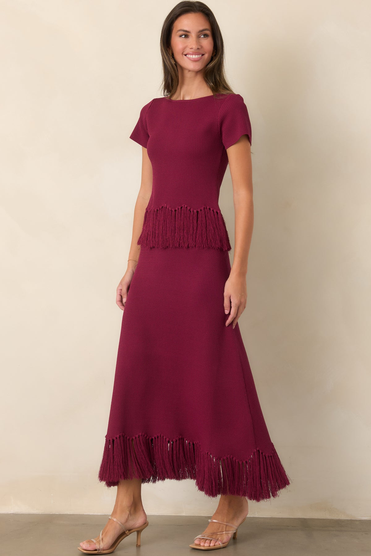 Rich berry textured knit skirt with a long silhouette and fringe-trimmed hem.