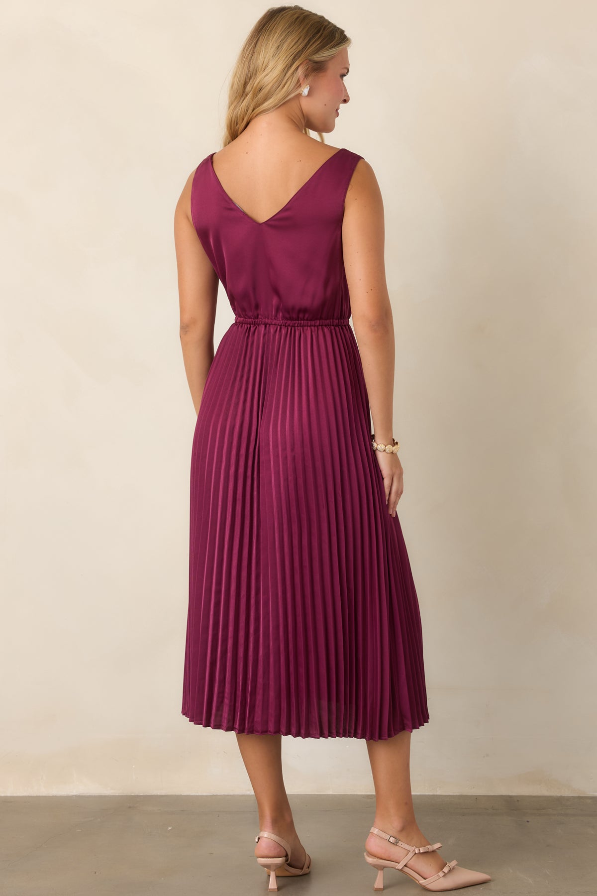 Rear of the berry two-piece set showcasing the open knit sweater and flowing satin skirt.