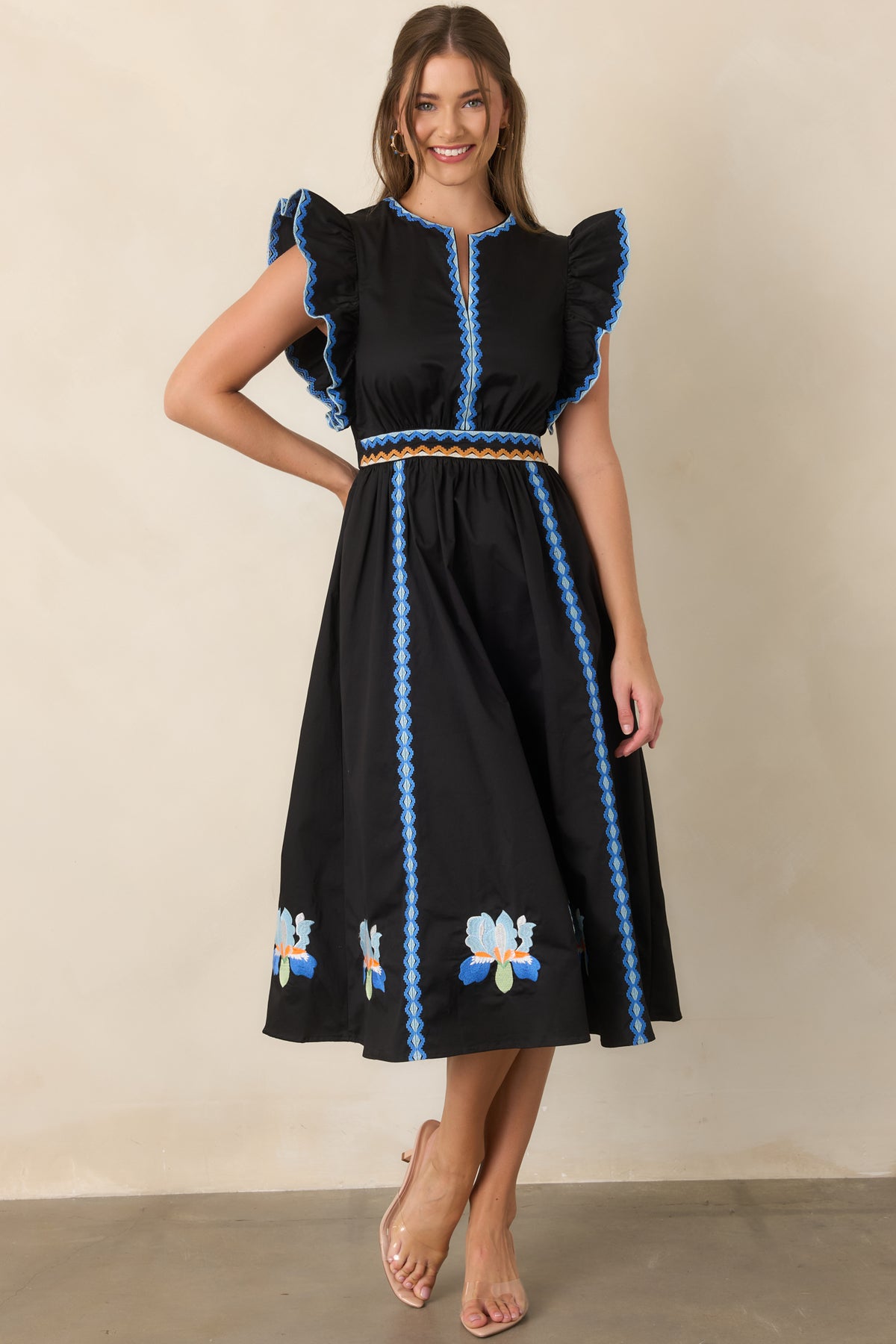 Black A-line dress showcasing colorful embroidery and a gathered skirt.