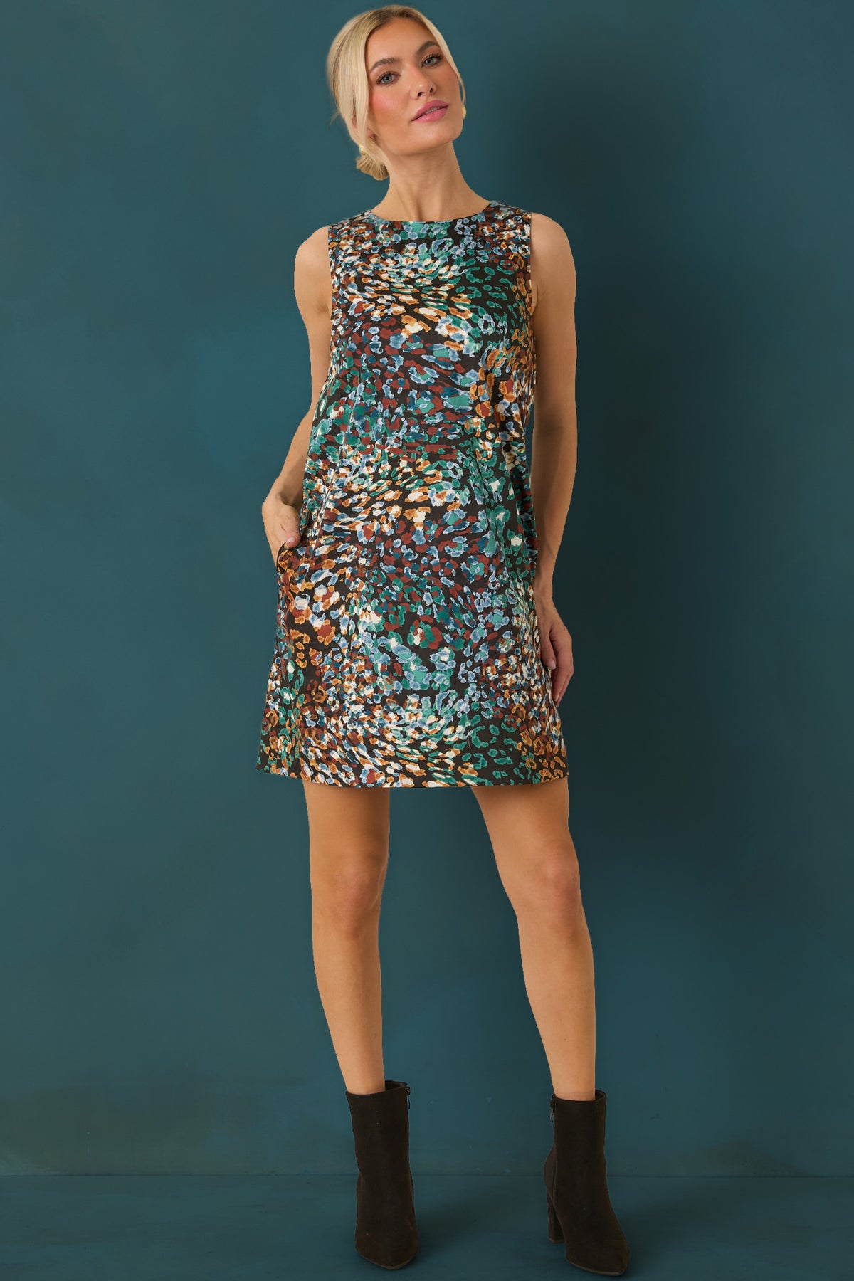 Black mini dress featuring an abstract animal print in rich green, blue, rust, and ivory.