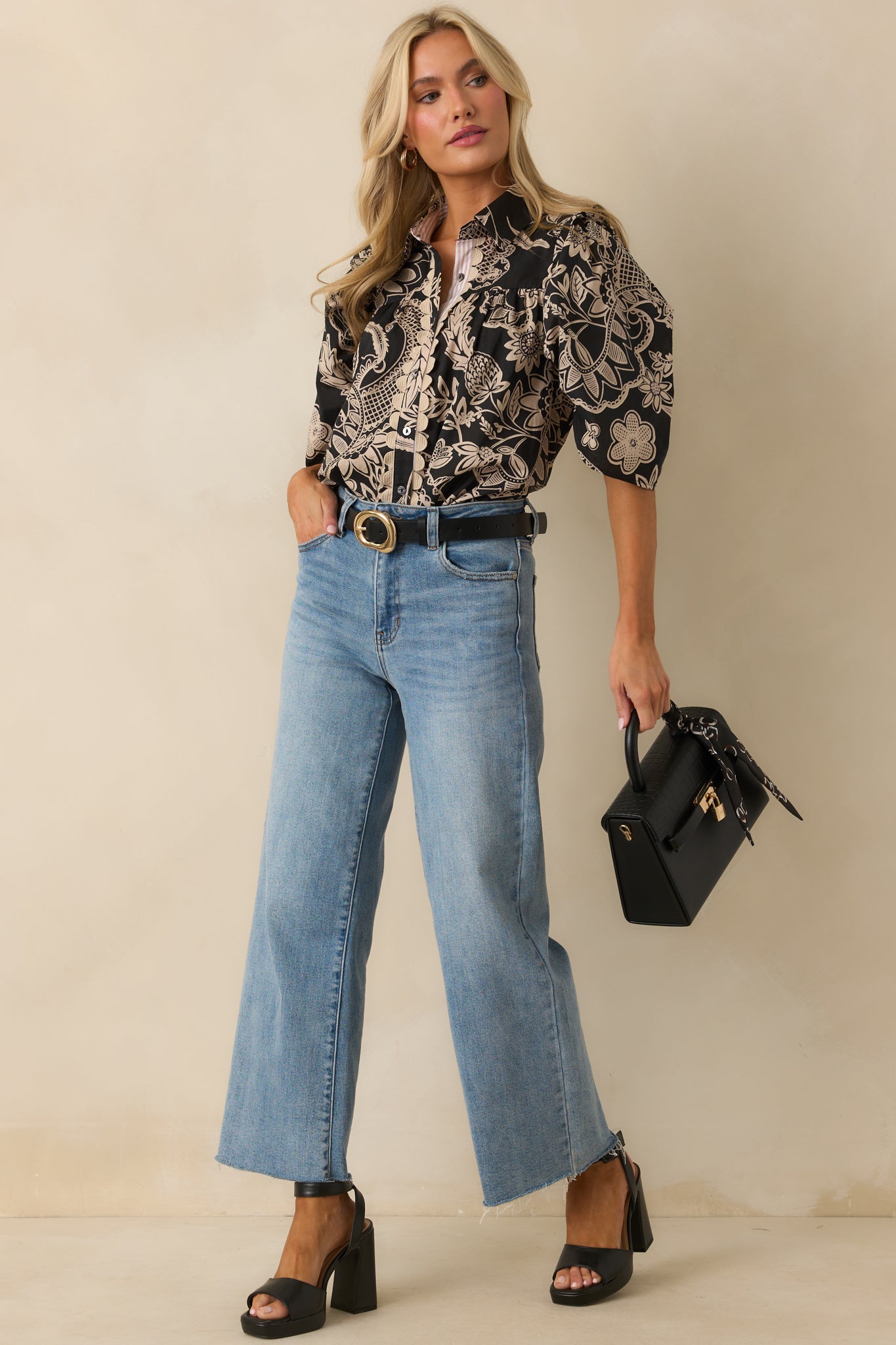 Black and beige floral cotton blouse with collared neckline, puff sleeves, and relaxed silhouette.