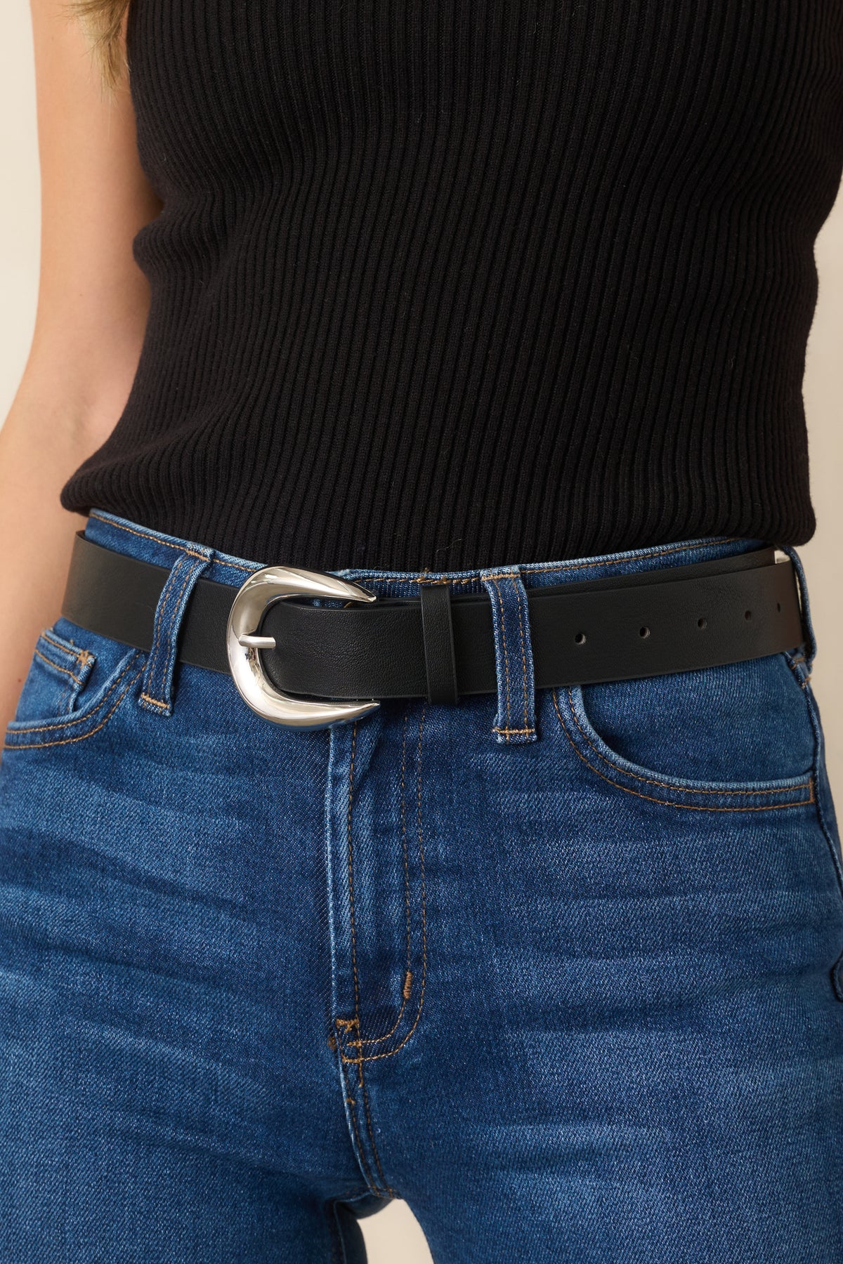 Close-up of the sculpted silver-tone buckle, curved edges, tapered tips, and smooth black strap.