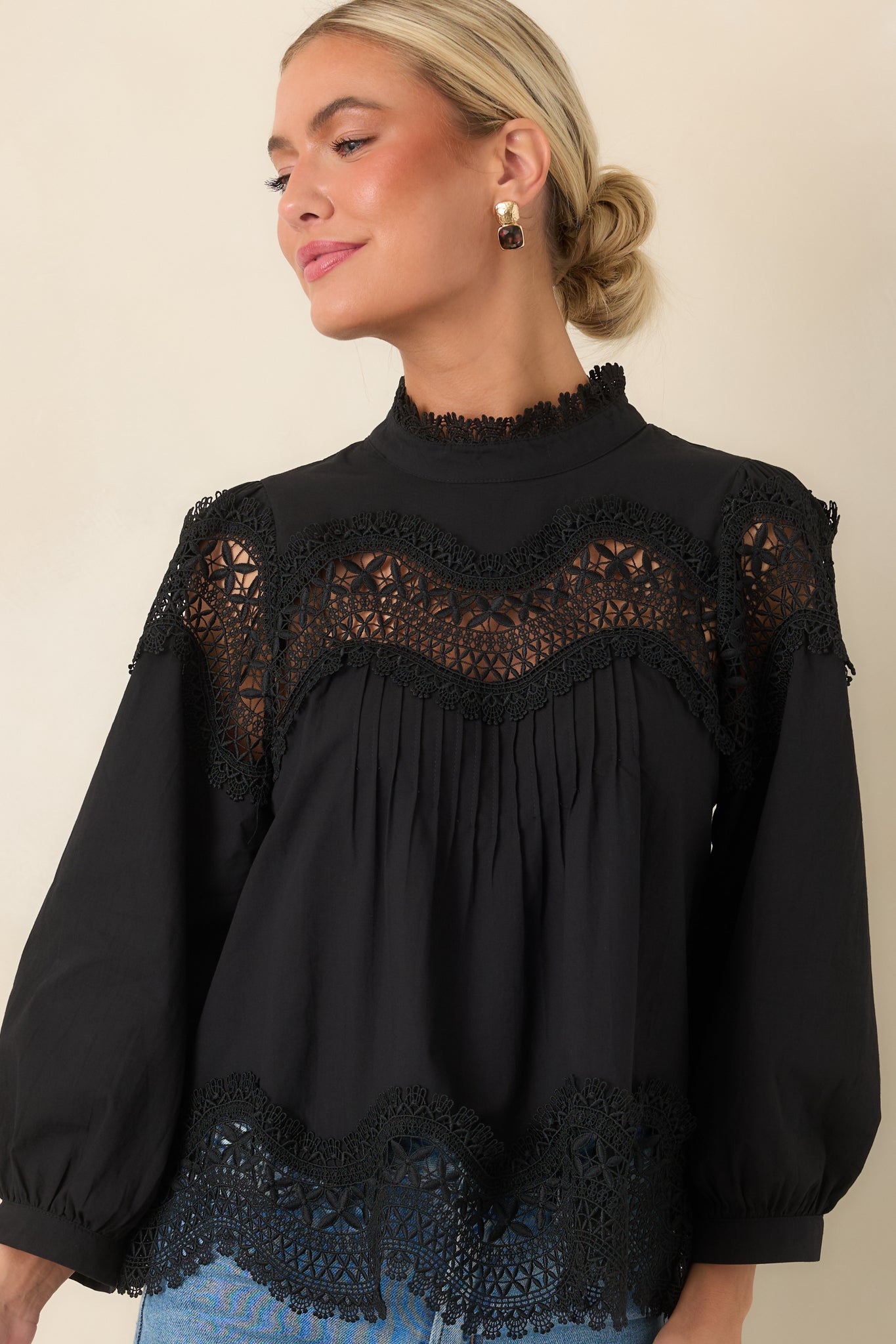 The front of this black blouse highlights the lace-trimmed neckline and scalloped openwork yoke.