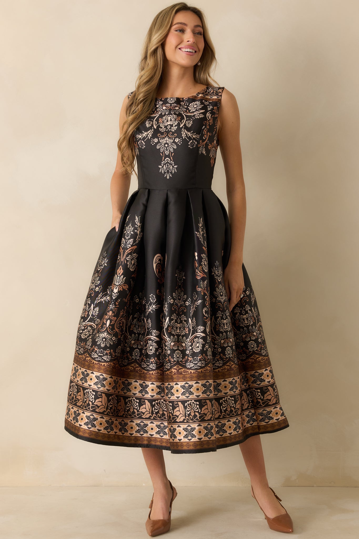 Full frontal shot highlighting the pleated skirt and polished fit of the black and bronze maxi dress.