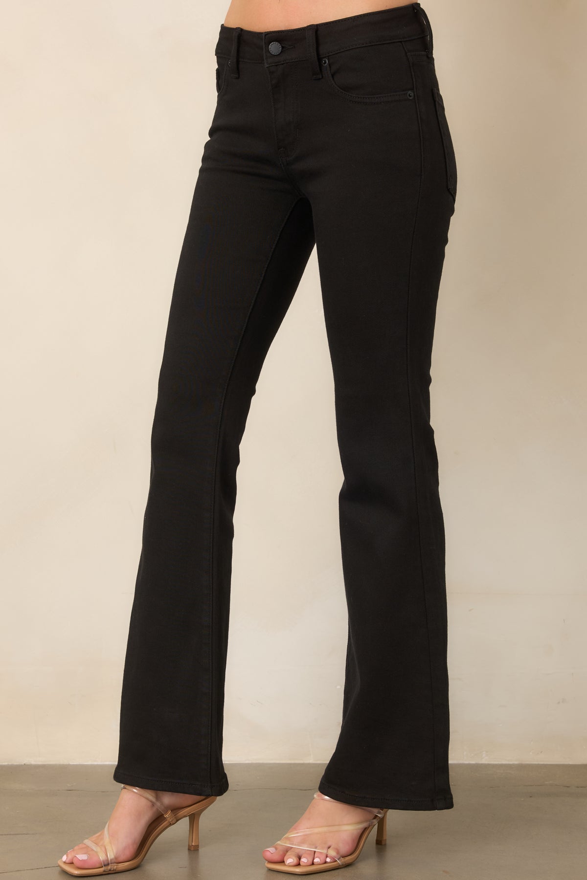 Black cotton-blend jeans featuring belt loops, a button-and-zip closure, and a flattering flared leg.
