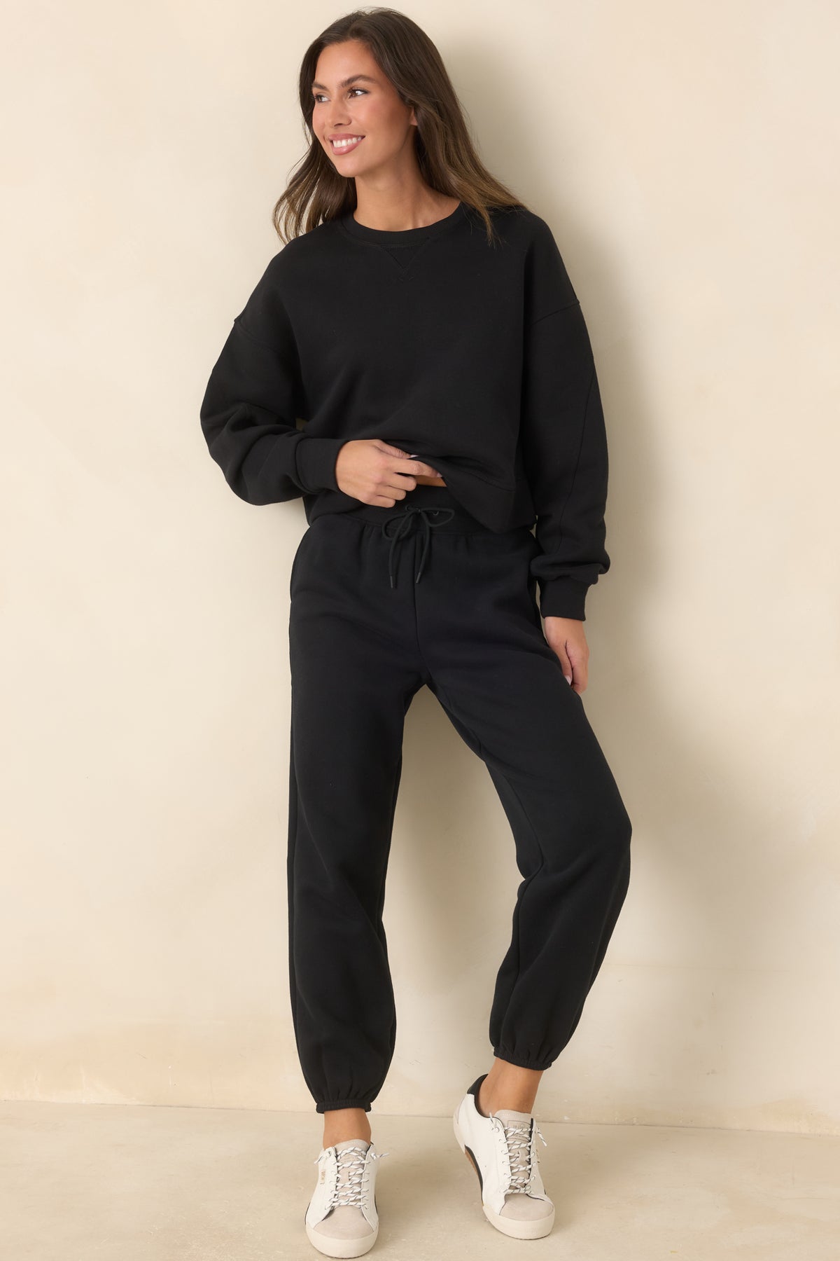Black cotton-blend fleece joggers with a high-rise ribbed waistband, roomy legs, and elasticized cuffs.
