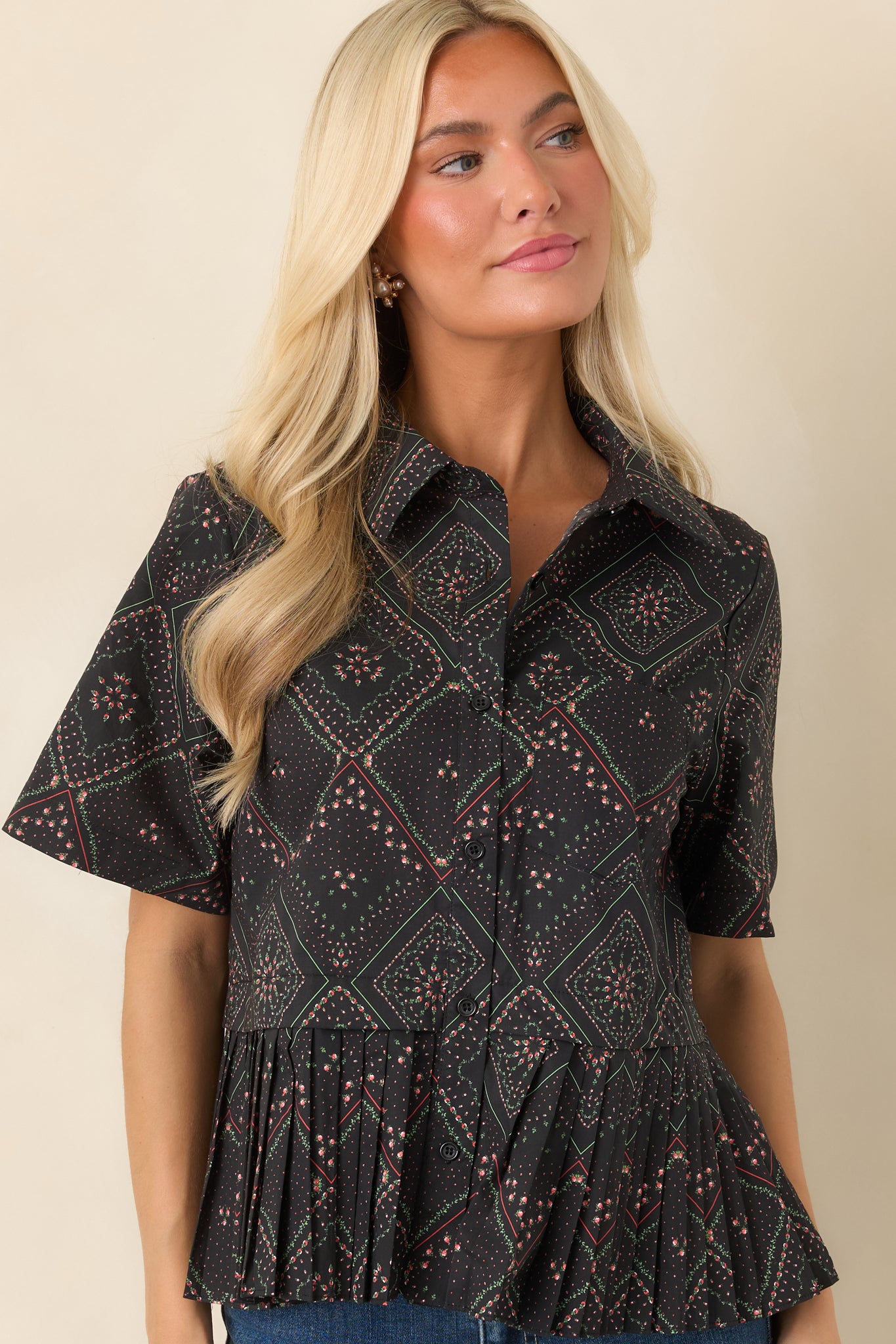 Black cotton blouse highlighting the vibrant coral and green floral pattern arranged in an intricate scarf-inspired geometric design.