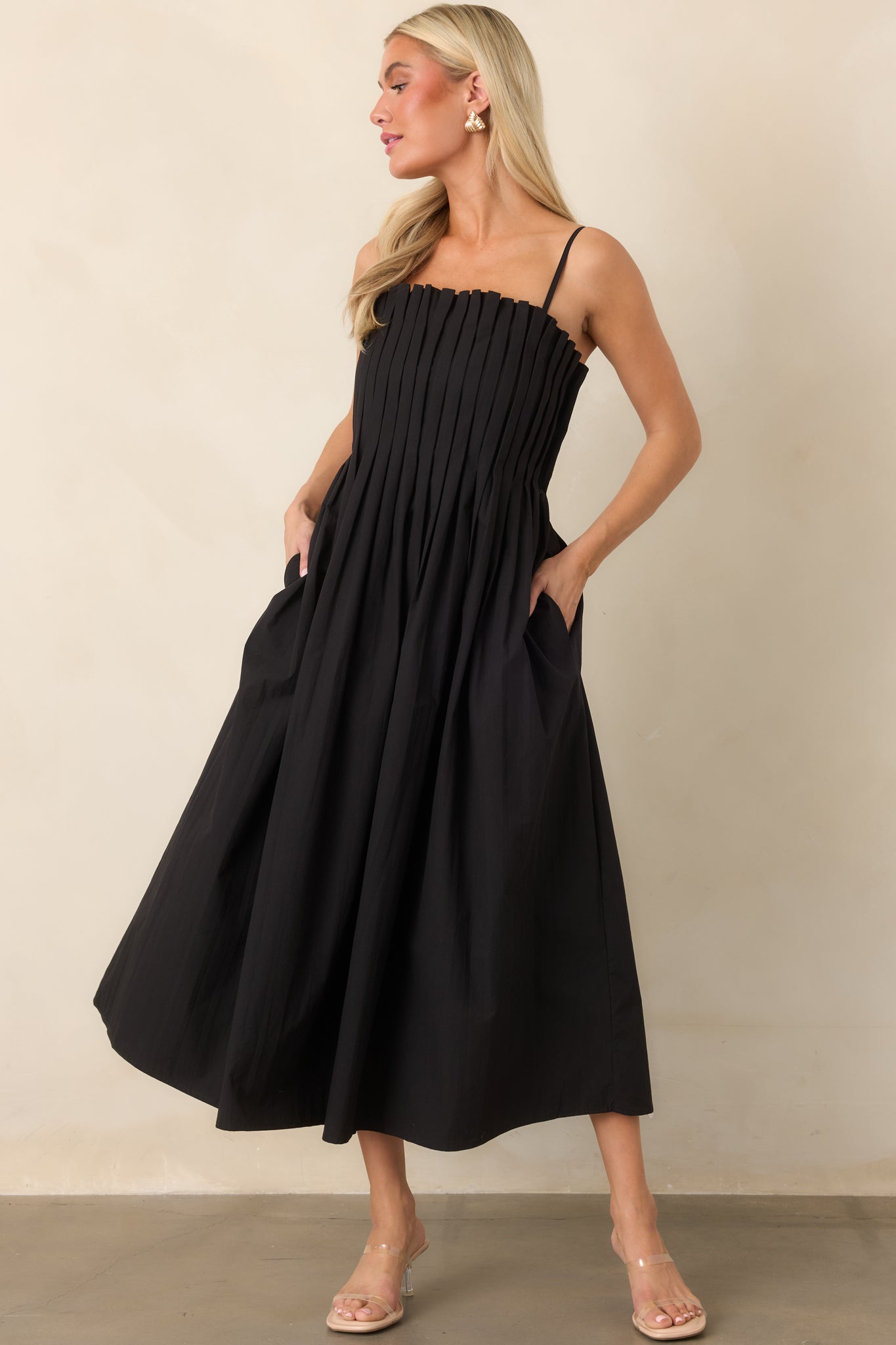 Elegant cotton midi dress with a square neckline, delicate spaghetti straps, full gathered skirt, and convenient side pockets.