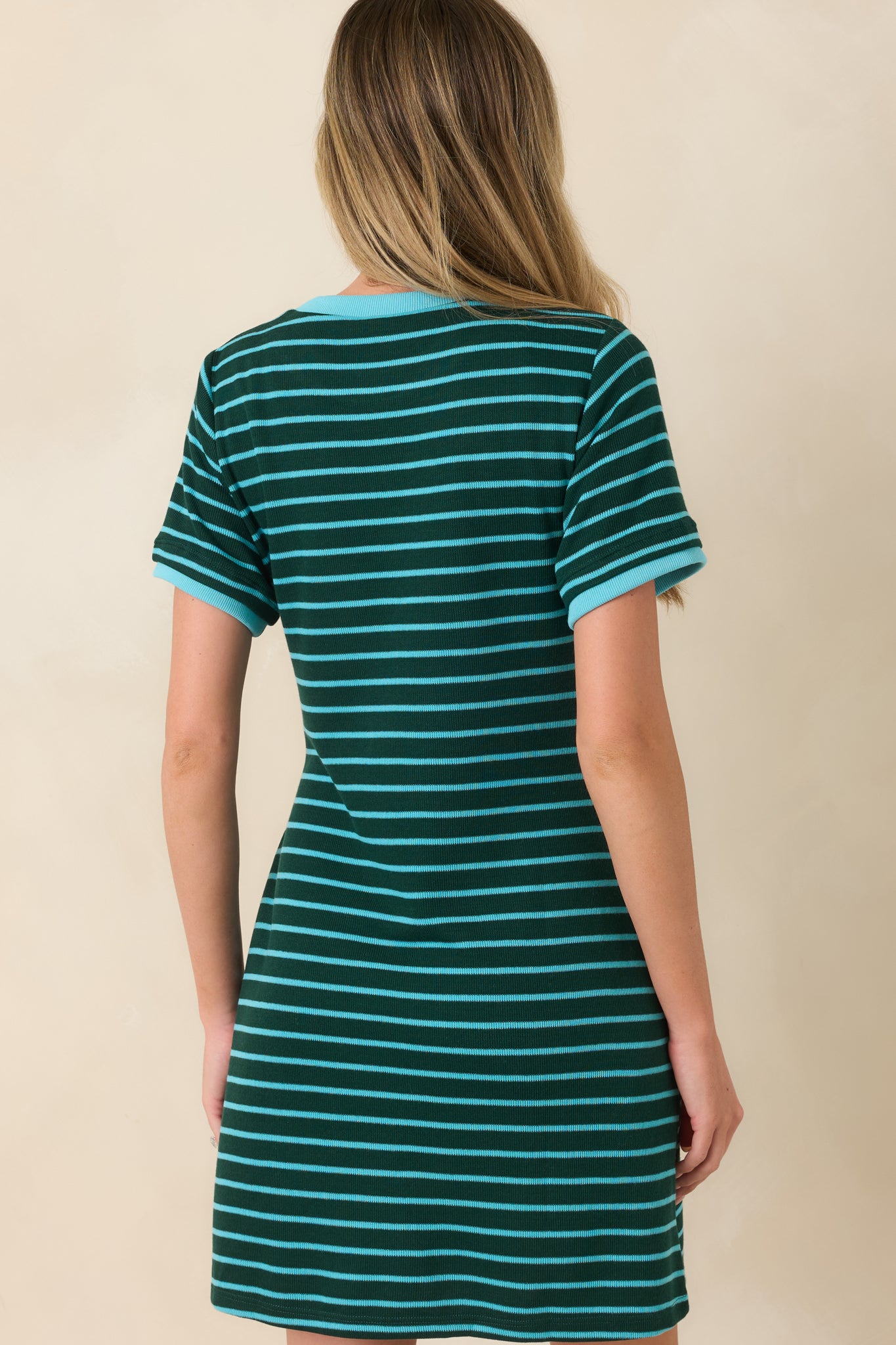 Back view of the black and cream striped mini dress featuring a relaxed fit, short sleeves, and a clean, uninterrupted striped design.