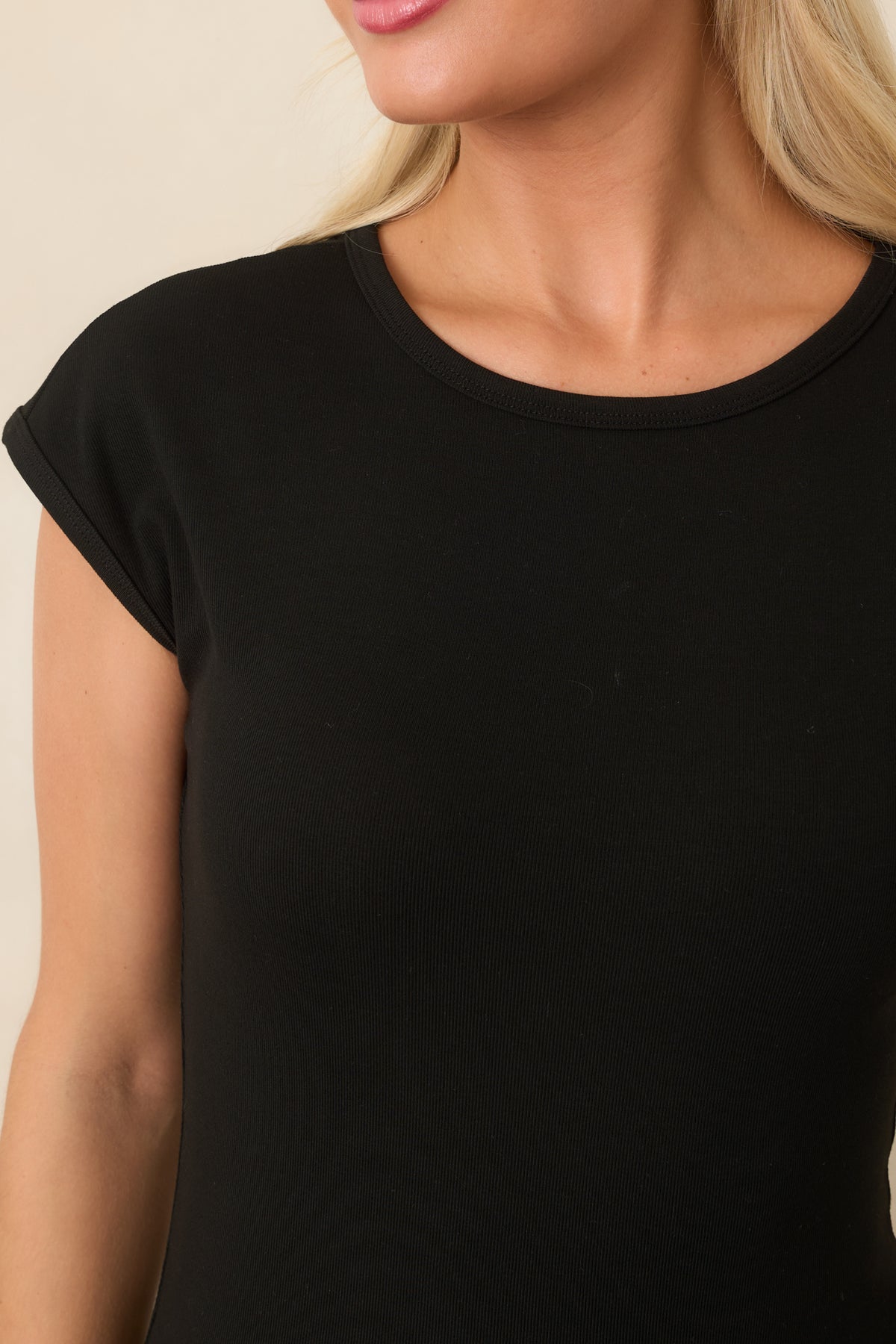 Close-up of the black crew neckline and smooth rayon-blend fabric.