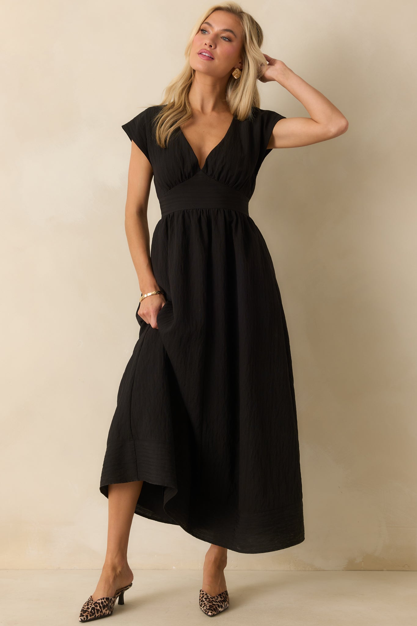 Black crinkle-textured dress highlighting the fitted bodice and flowing skirt.