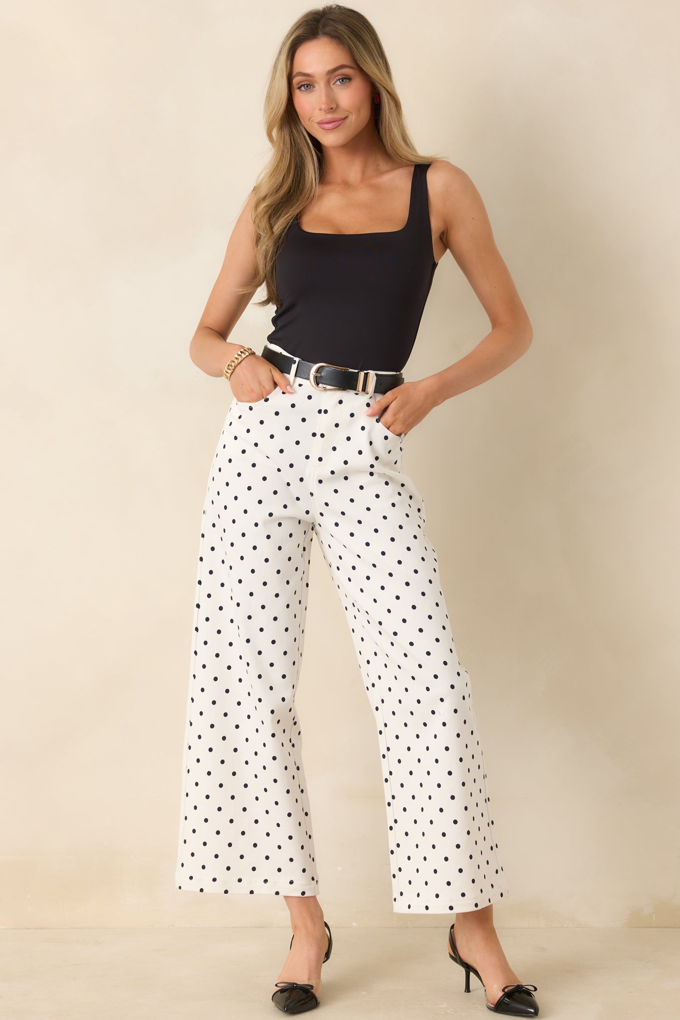 Black dot patterned pants on ivory base with structured fit and easy straight-leg shape.