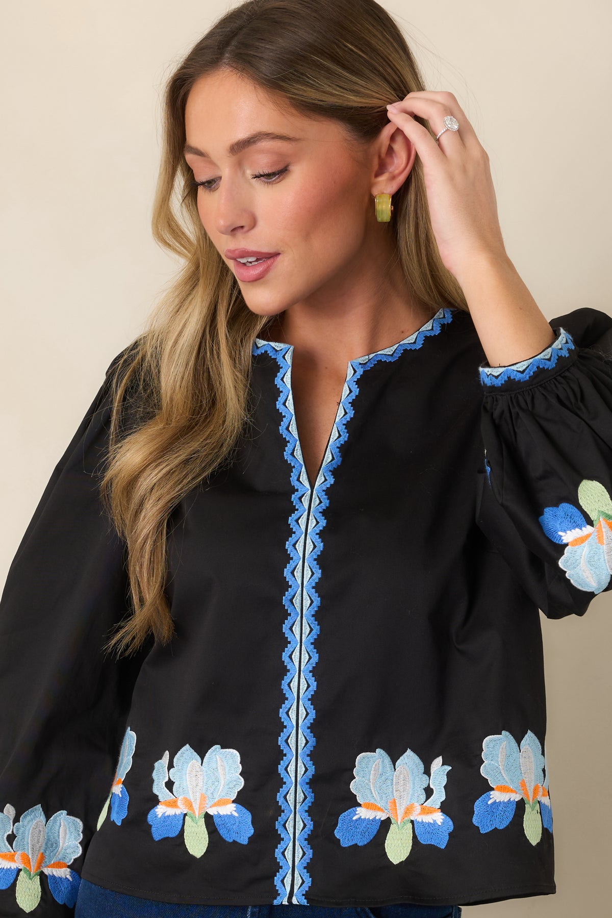 Black embroidered blouse showcasing geometric cuff embroidery and puff sleeves.