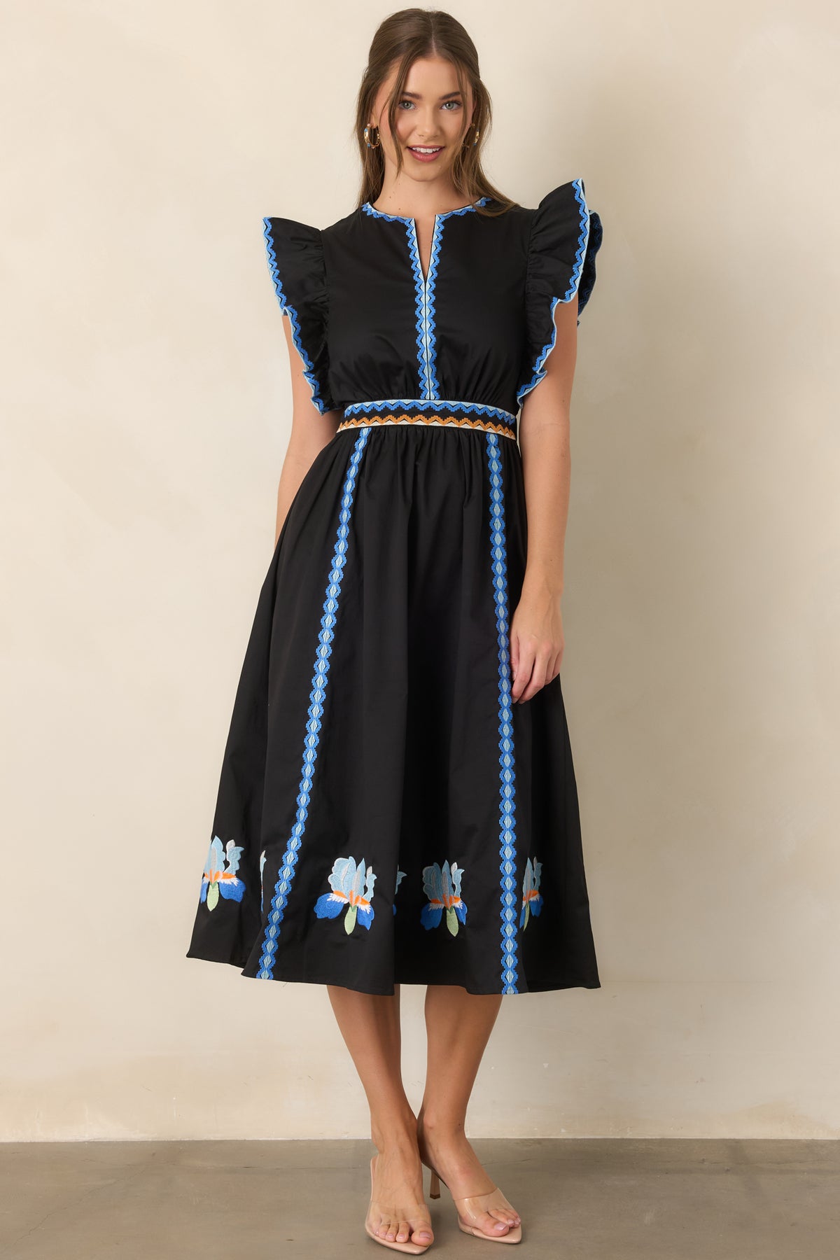 Black embroidered dress showcasing the split neckline and defined waist.