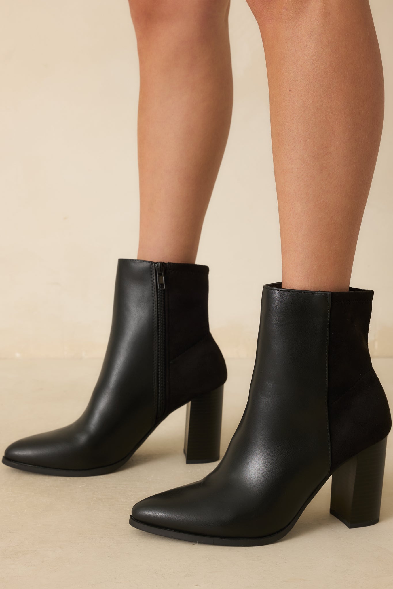 Cropped photo showing the black ankle boots with a smooth faux leather front and pointed toe design.