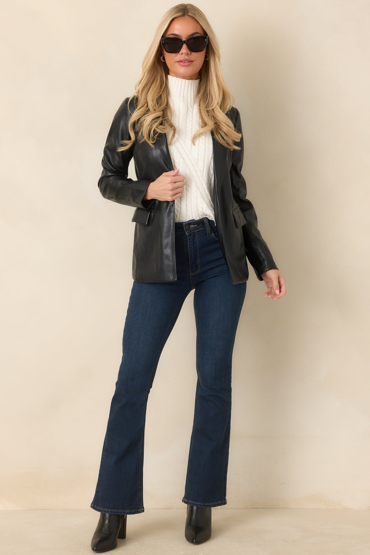Black faux leather blazer with notched lapels, curved waist seams, and front flap pockets.