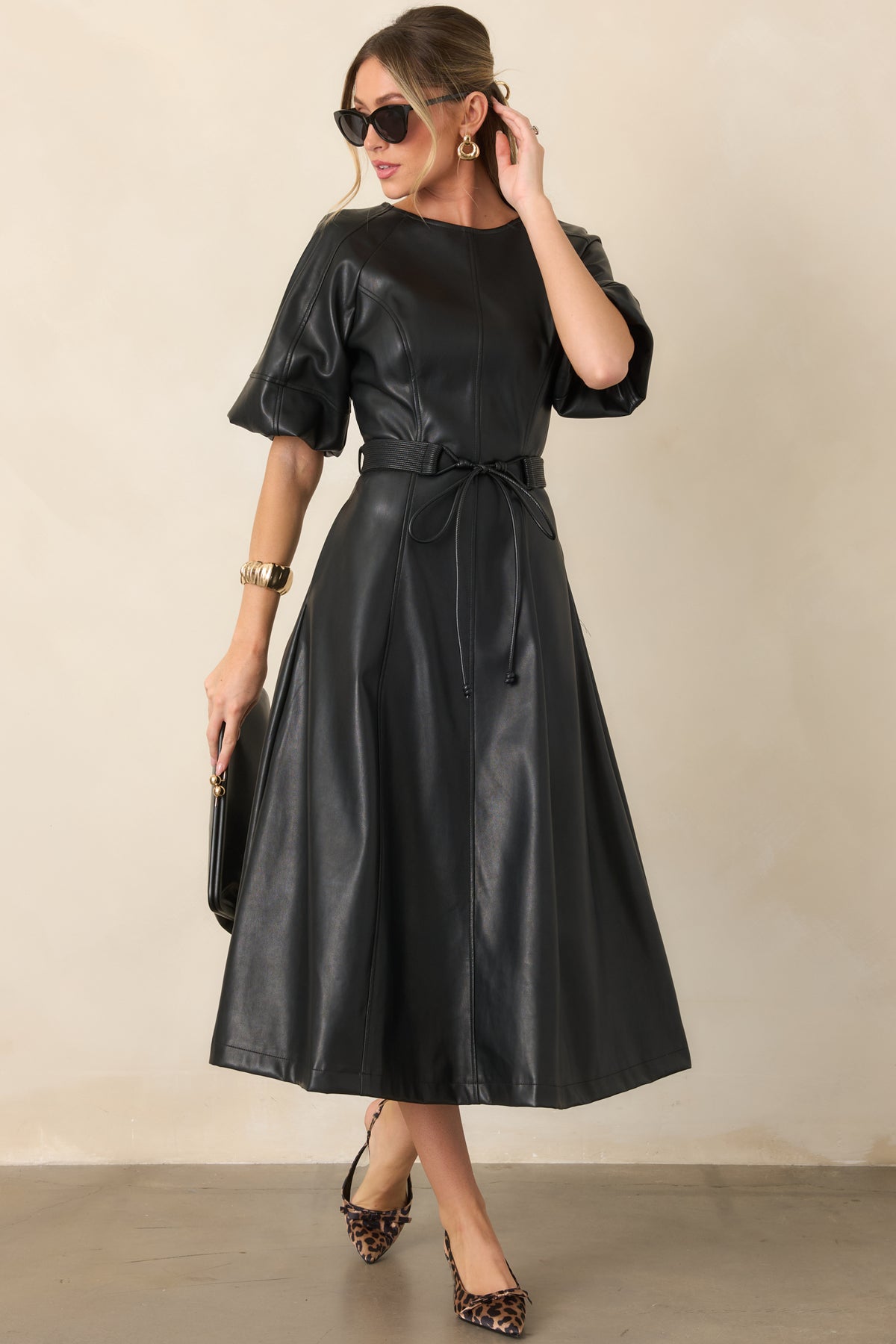 Black faux leather dress with a polished crew neckline, raglan sleeves, and softly draped skirt.