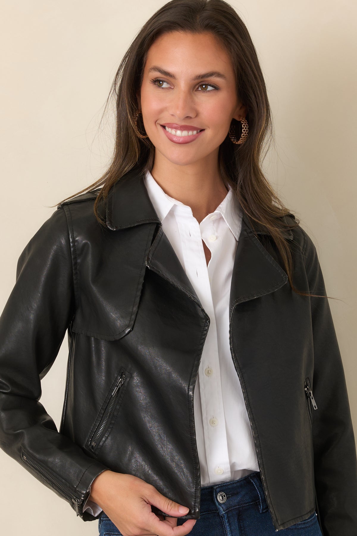 Black faux leather jacket showcasing its cropped silhouette, wide notched lapels, and open front.