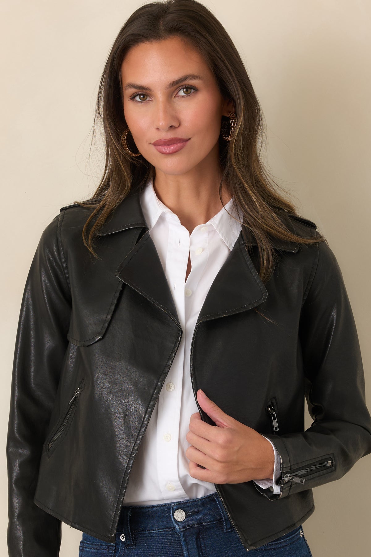 Black faux leather jacket featuring wide notched lapels and zippered side pockets.