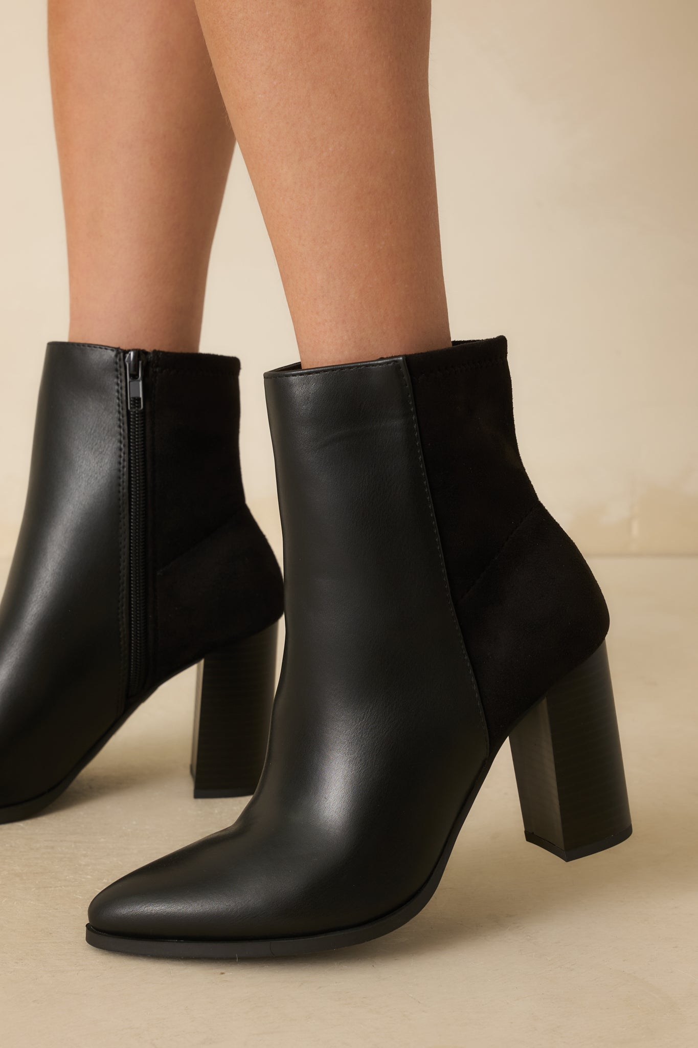 Cropped image highlighting the tonal faux suede back panel and black stacked block heel.