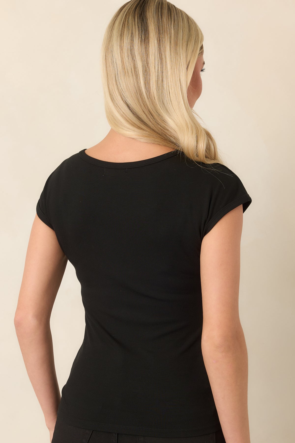 Rear of the black fitted top showing its smooth close-to-body silhouette.