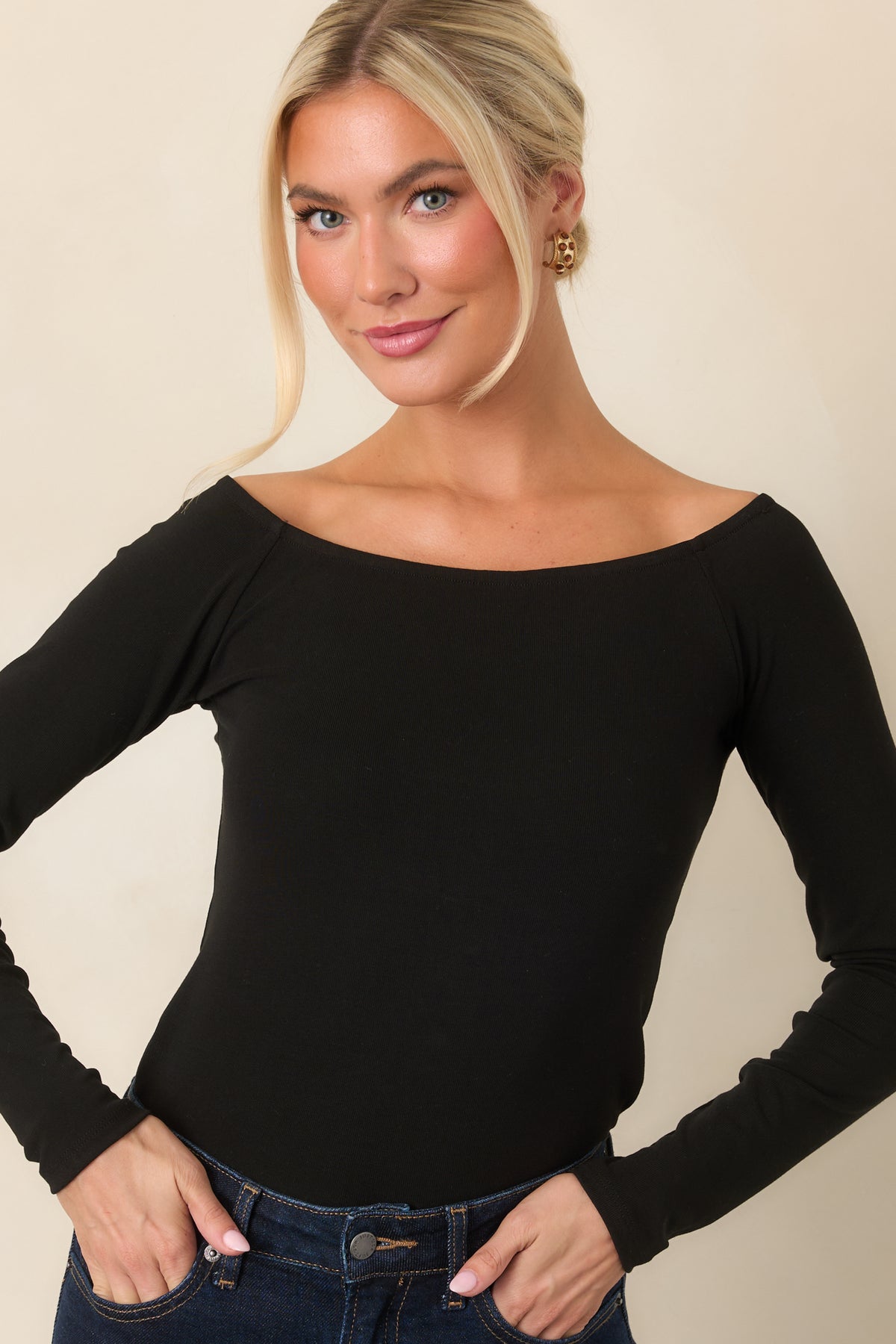 Black fitted top highlighting the smooth fabric, wide neckline, and long sleeves.