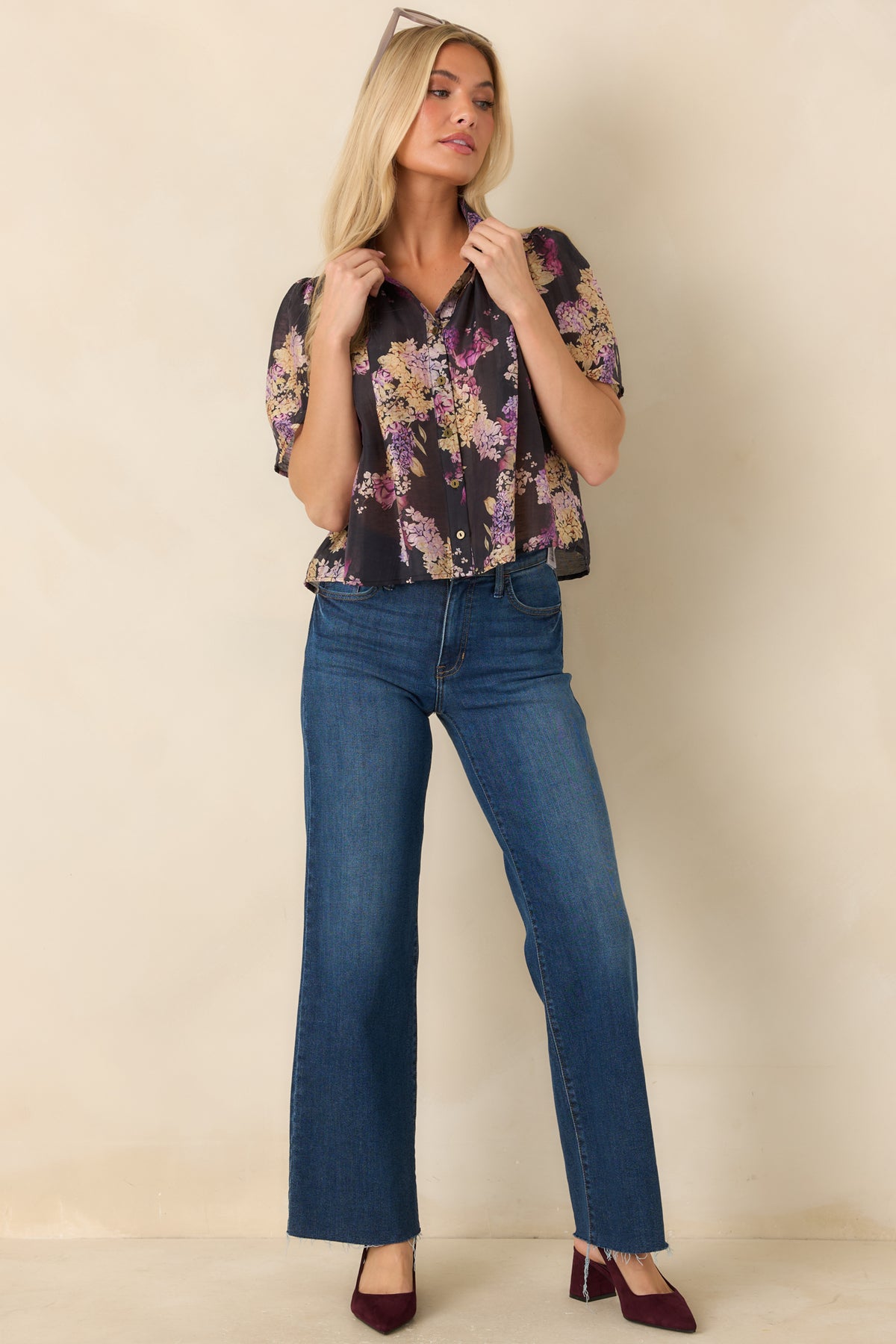 Lightweight black floral blouse featuring a button-front closure, softly gathered shoulders, and a slightly cropped hem.