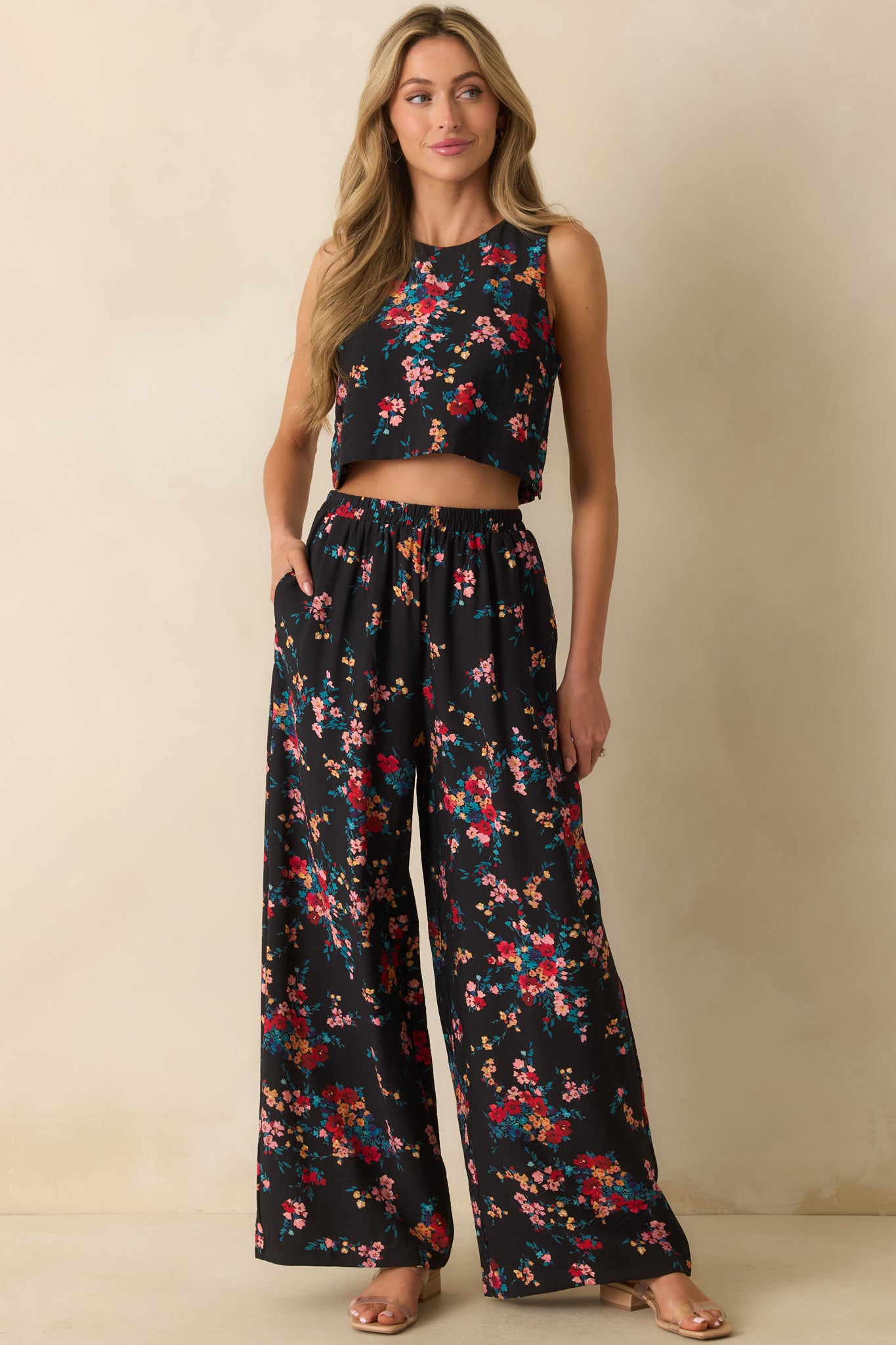 Black floral crop top with a round neckline and sleeveless design in a relaxed fit.