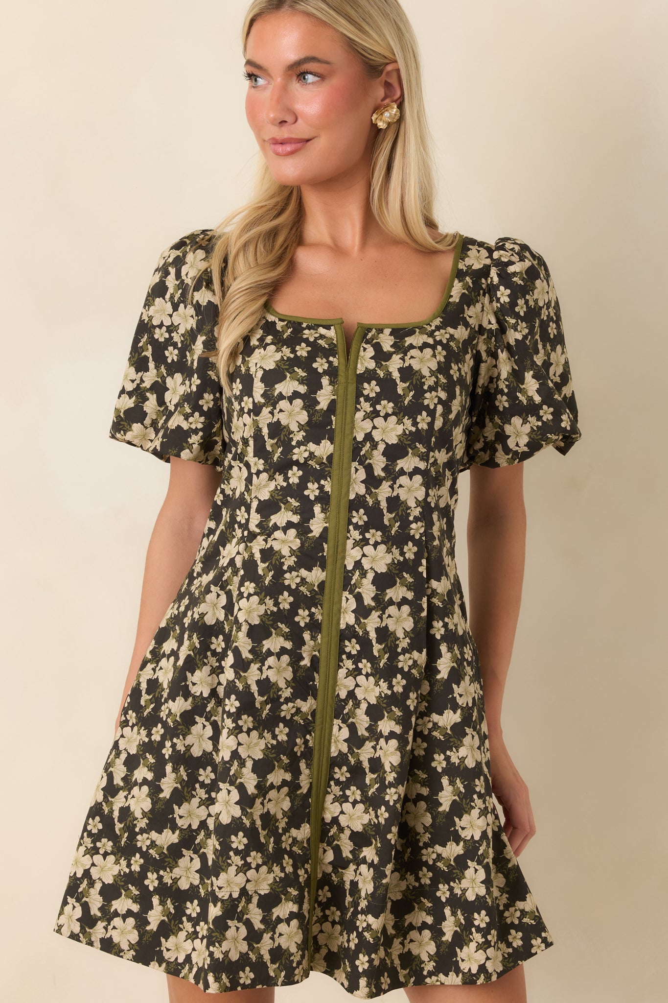 Black floral dress featuring structured pleating at the waist and a polished fit-and-flare silhouette.